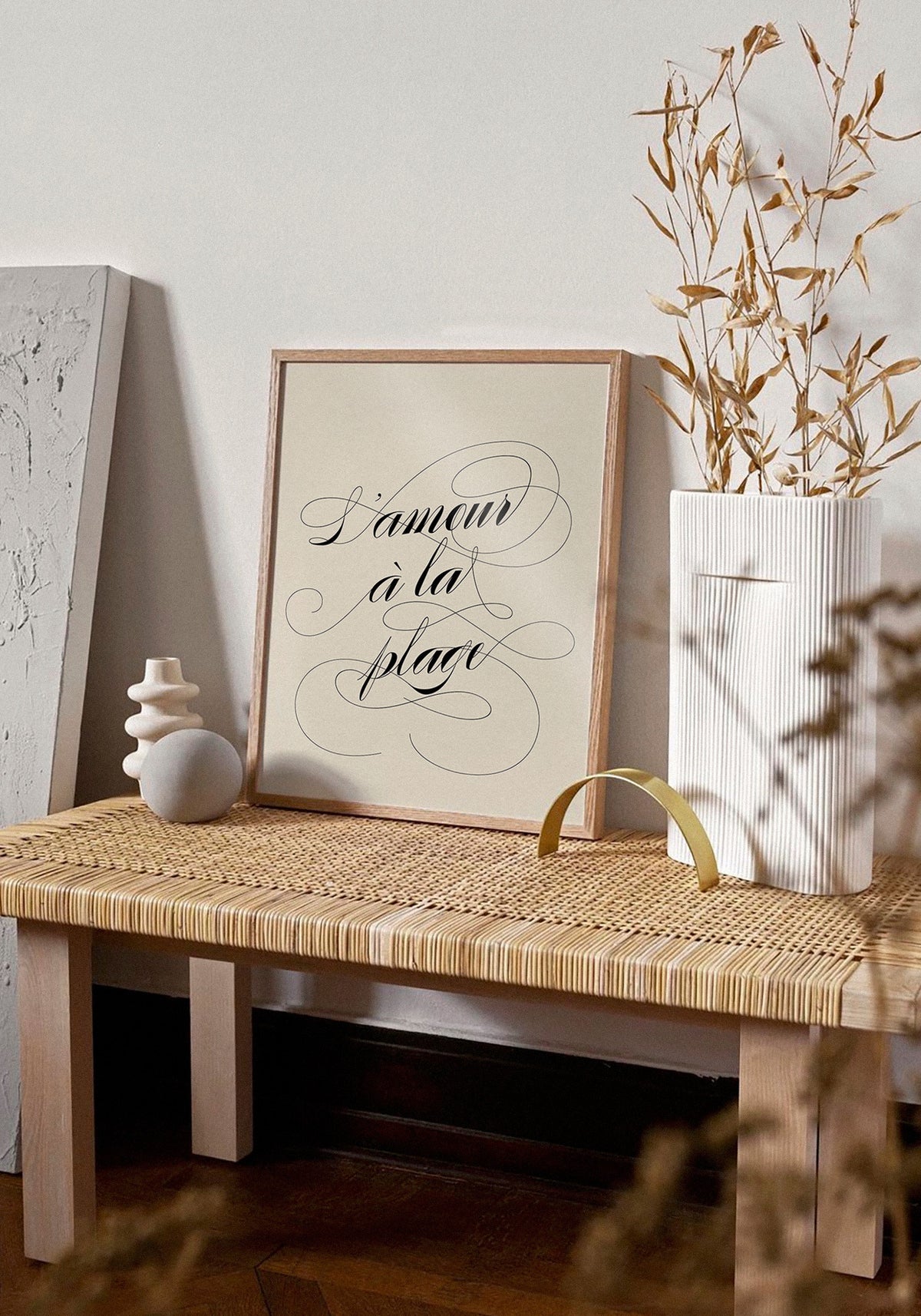 L'affiche typographique "L'amour à la plage" en 21x30 cm de chez Studio Topo posée sur un banc en bois