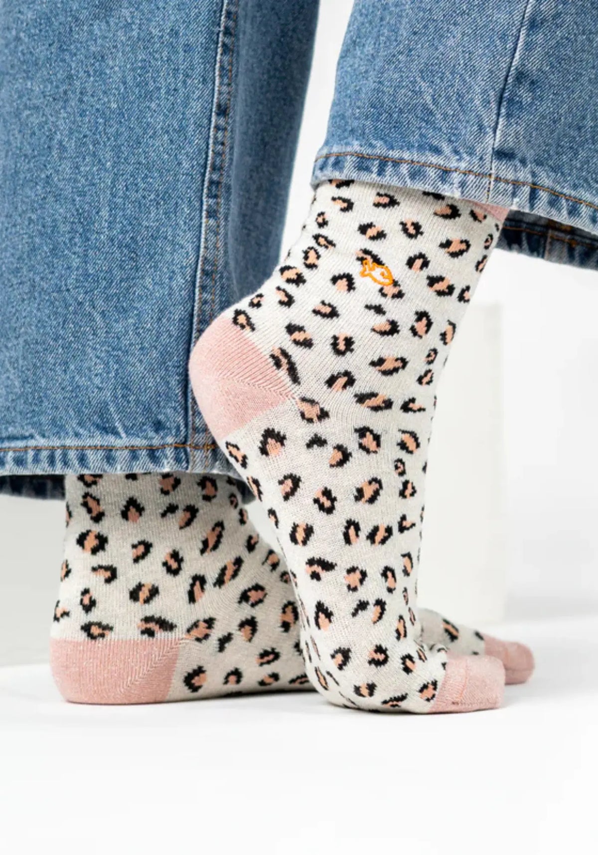 La femme porte les chaussettes à motif léopard blanc de chez Billy Belt