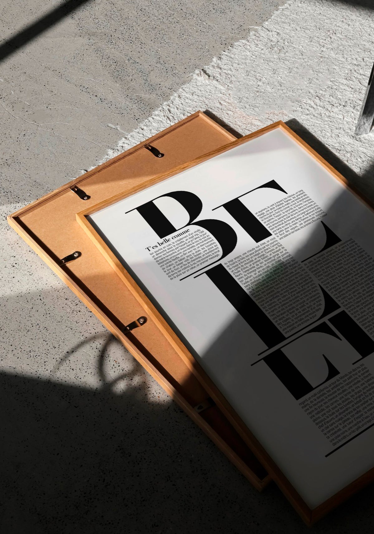 L'affiche typographique "T'es belle comme" en 30x40 cm de chez Studio Topo posée à plat au sol