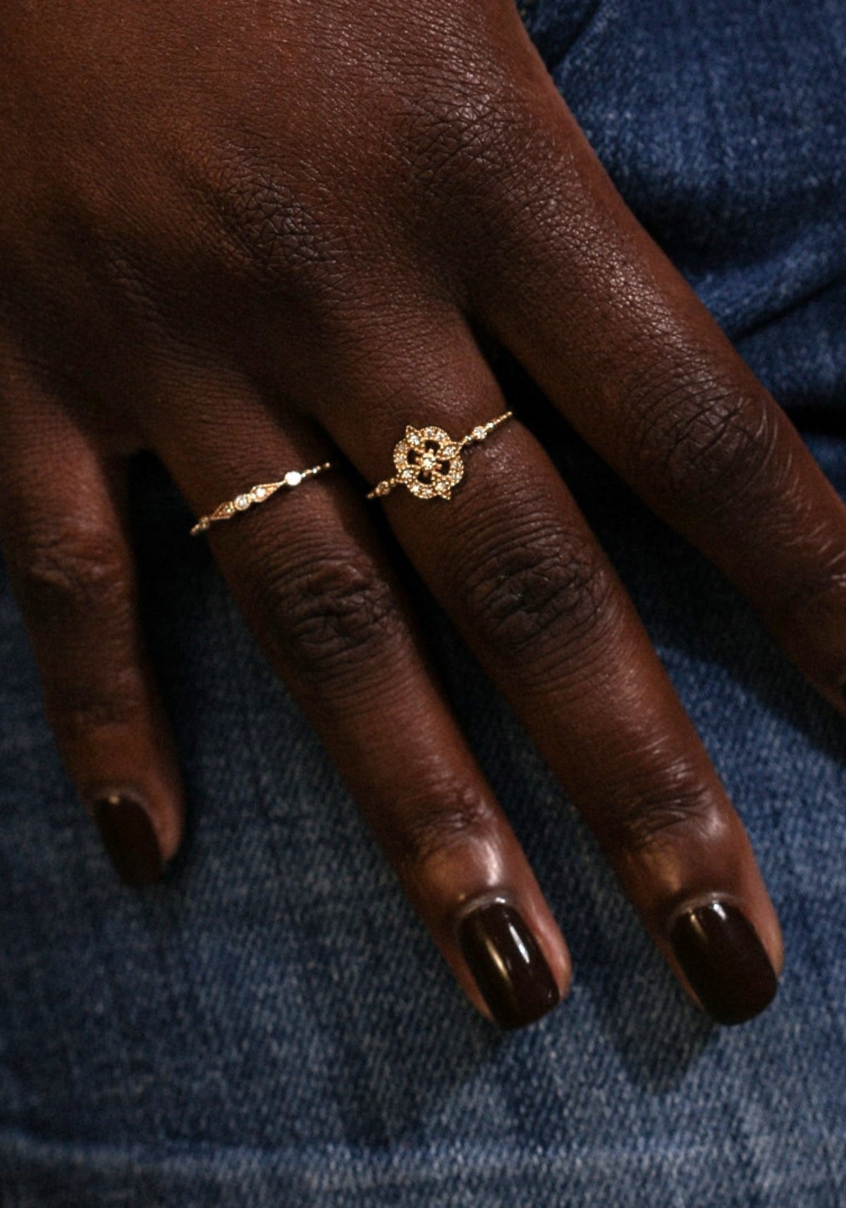 La femme porte à son majeur la bague en or jaune Gina Star de chez Angèle Brousse