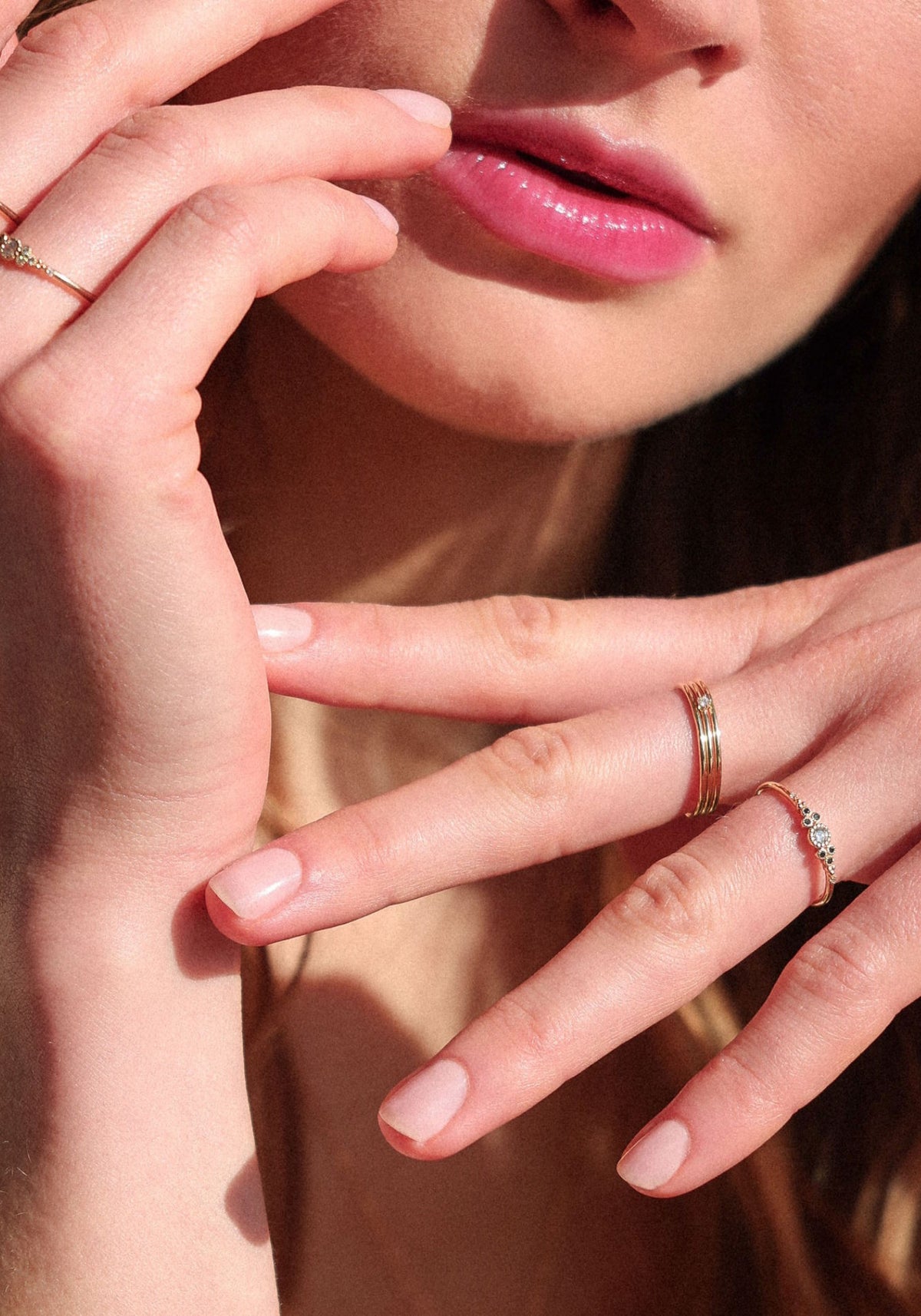 La femme porte la bague Little Paradis Diamants Noirs de chez Angèle Brousse au niveau de son annulaire.