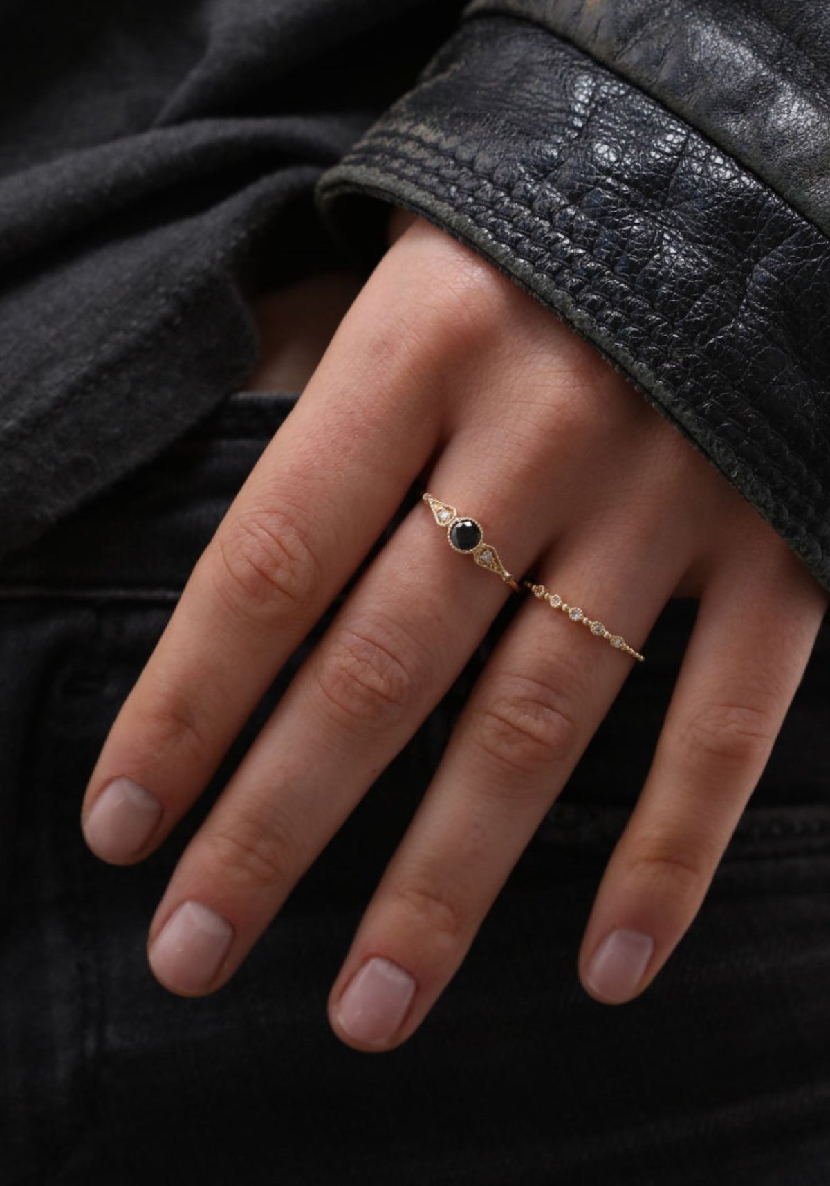 La femme porte la bague Nina Small en or jaune de chez Angèle Brousse en ayant la main au niveau de la poche de son jean.
