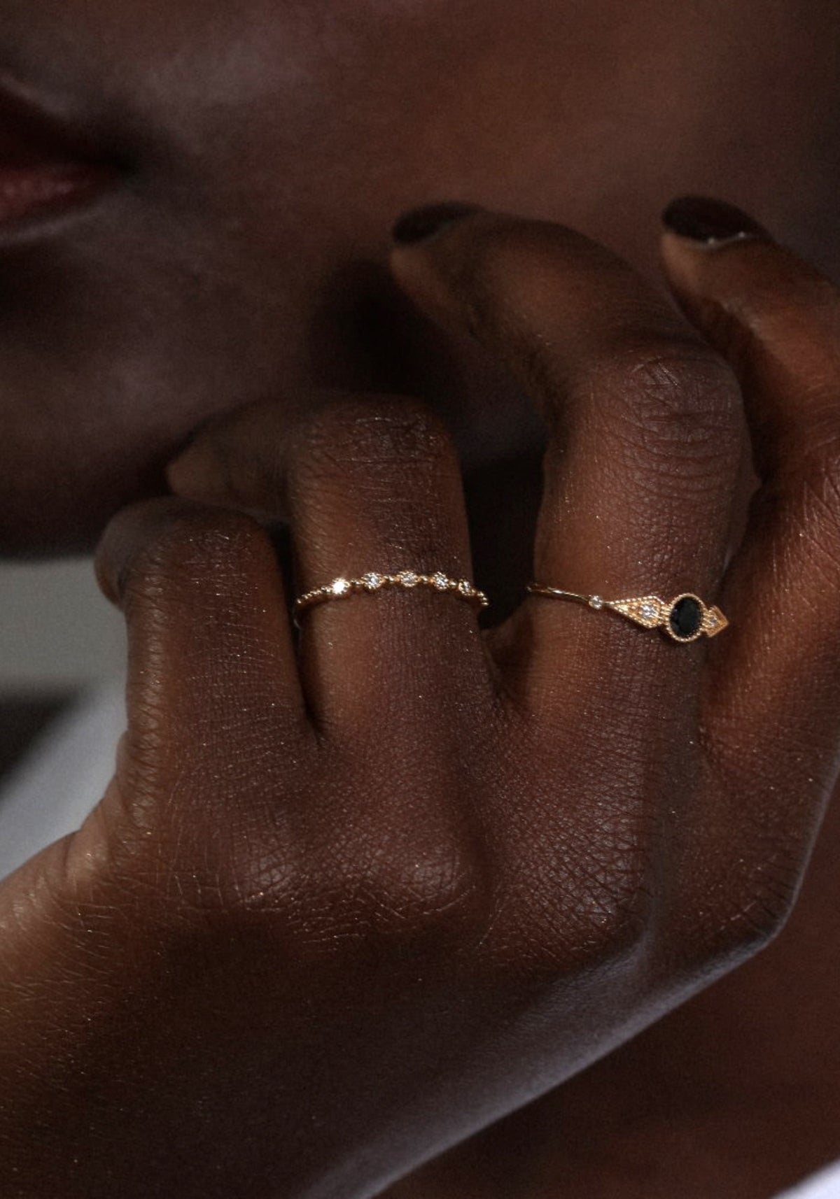La femme porte la bague Nina Small en or jaune de chez Angèle Brousse au niveau de son annulaire.