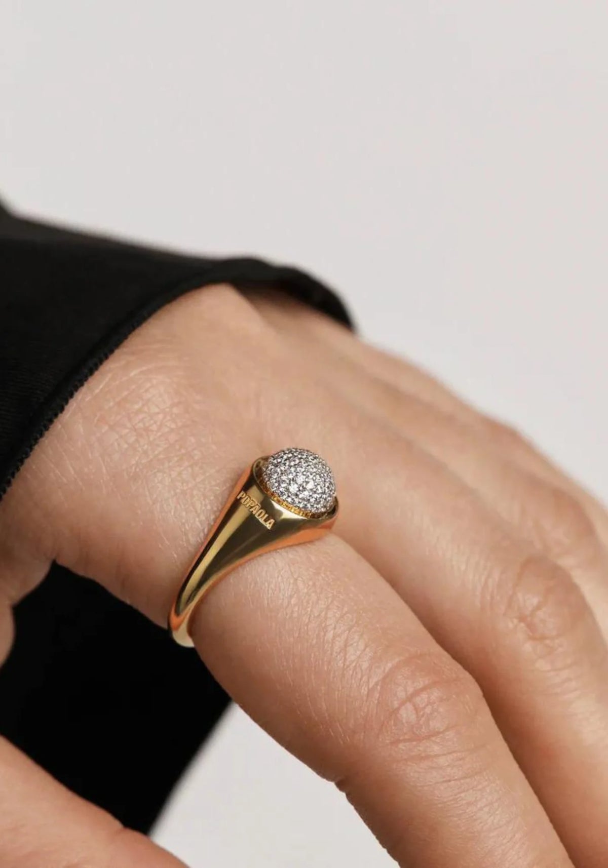 Zoom sur la main de la femme qui porte la bague pavée en or jaune 18 carats Moon de chez PD Paola