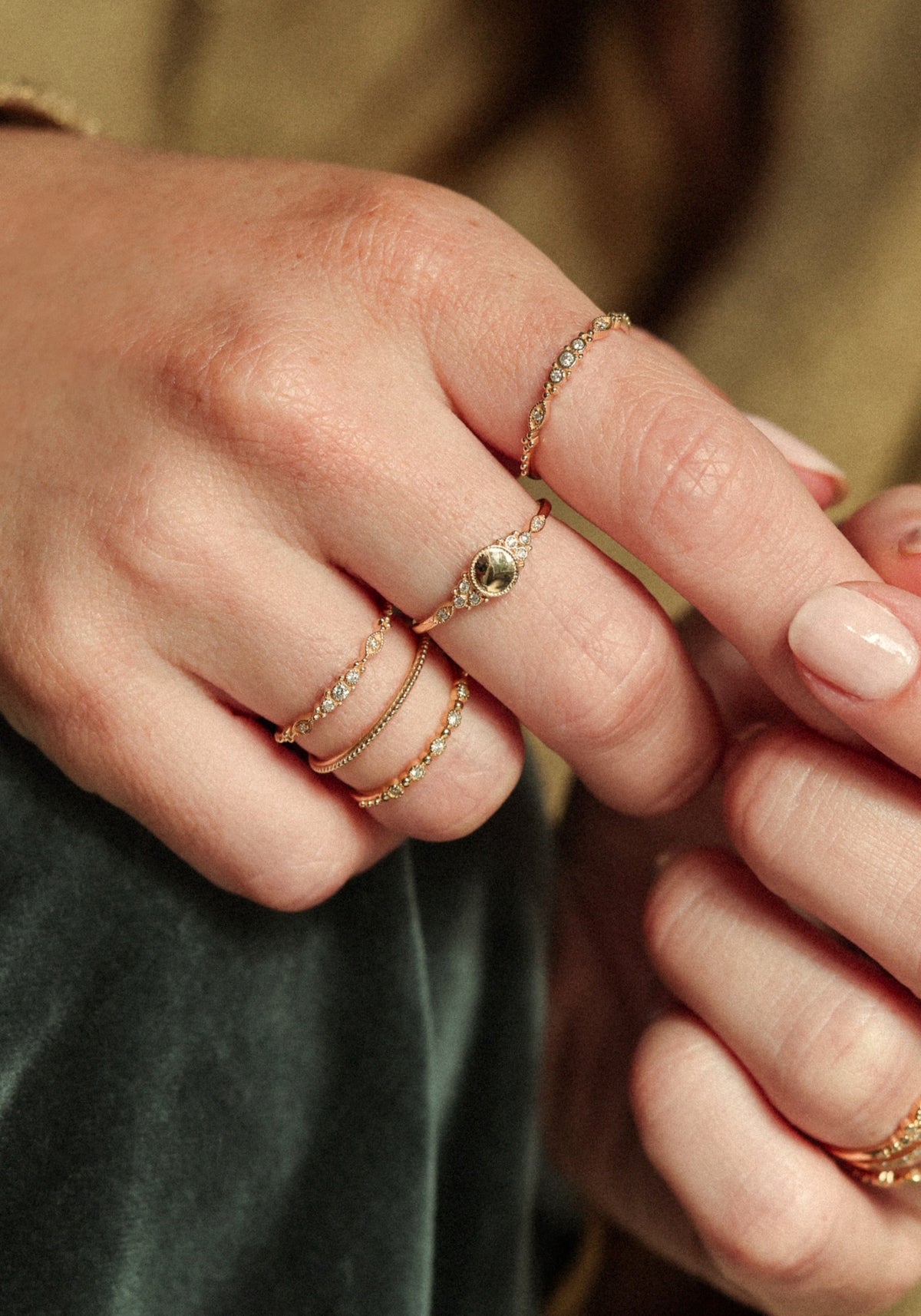 La femme porte la bague Susie Gold de chez Angèle Brousse au niveau du majeur.