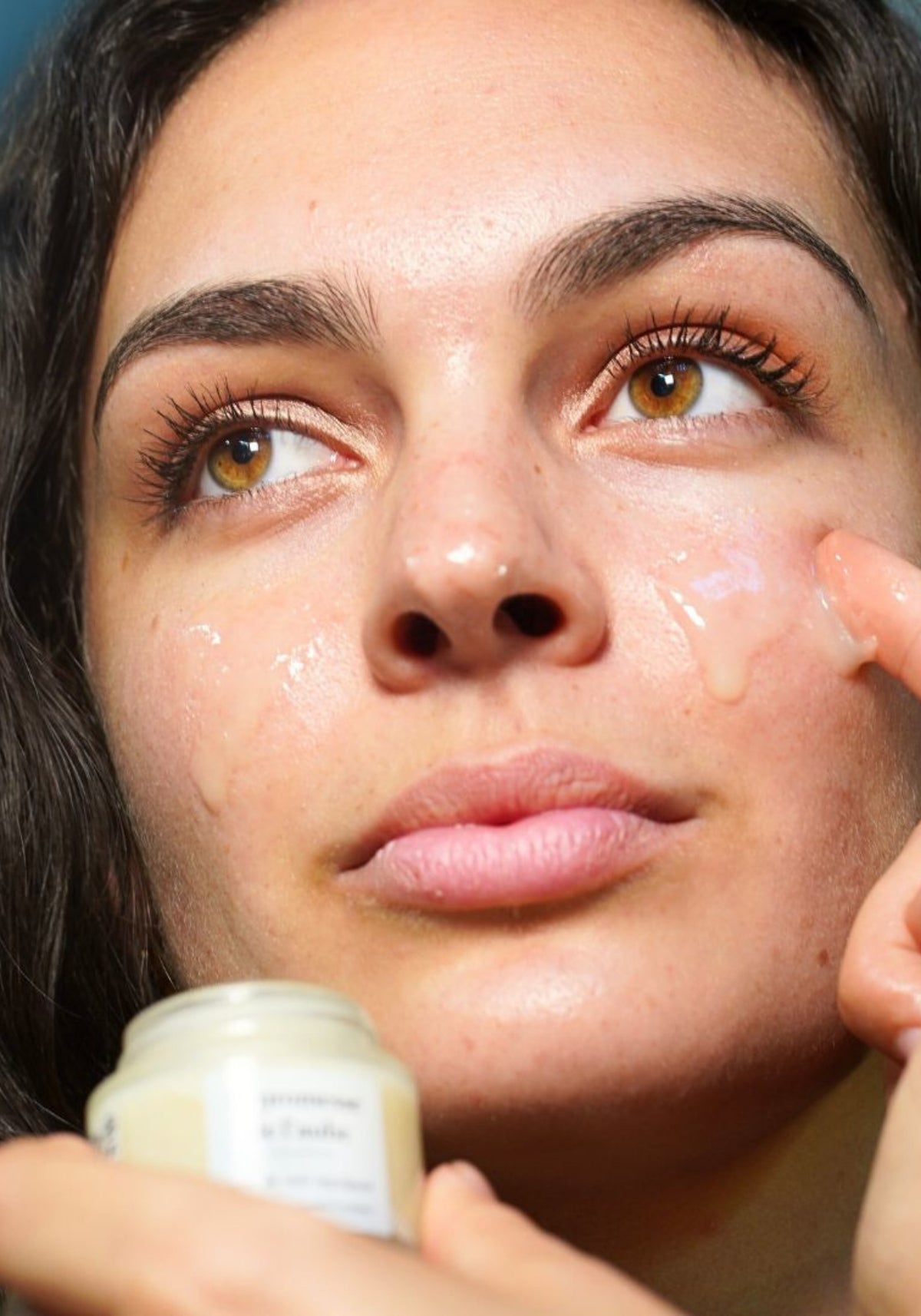 La femme applique le baume soin de nuit La Promesse de L'aube de chez Mira sur son visage