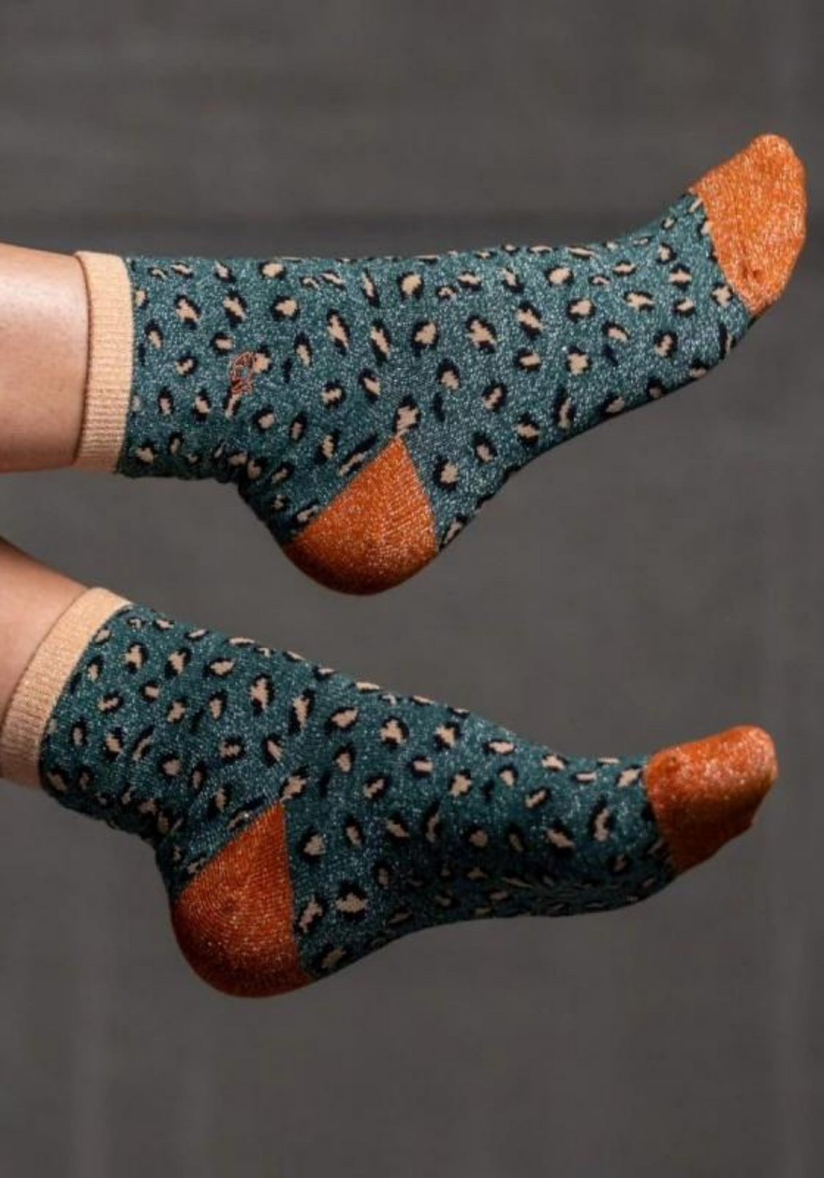 la femme porte les chaussette leopard de couleur verte et camel