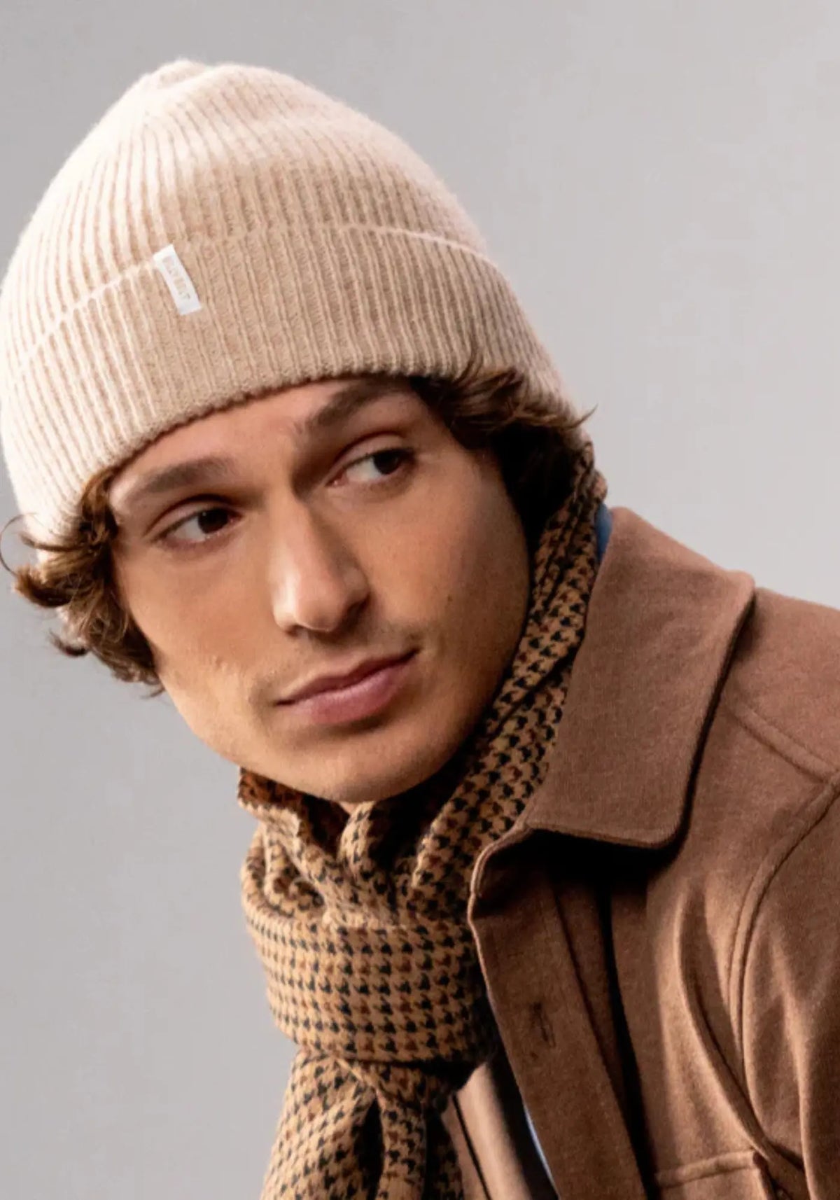 L'homme porte le bonnet en laine pour homme beige de chez Billybelt