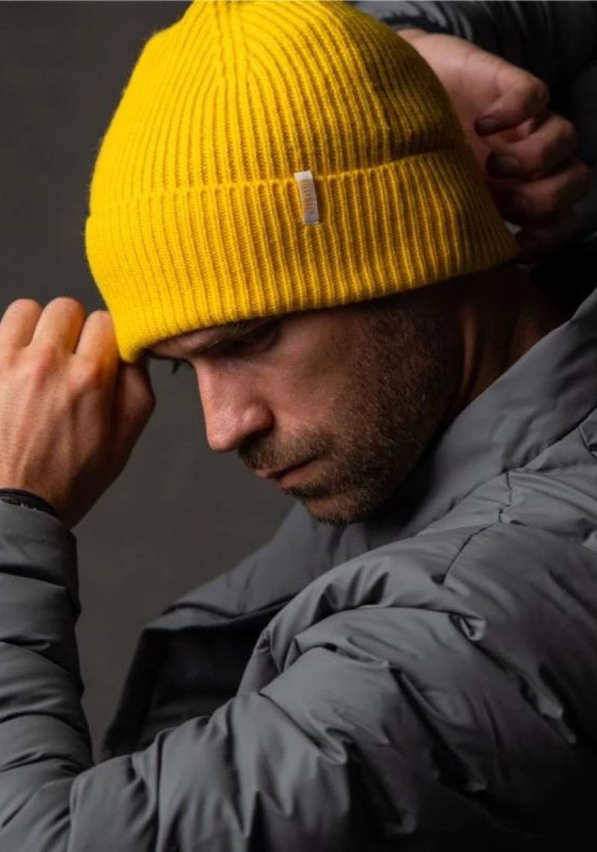 L'homme porte le bonnet en laine jaune de chez Billybelt