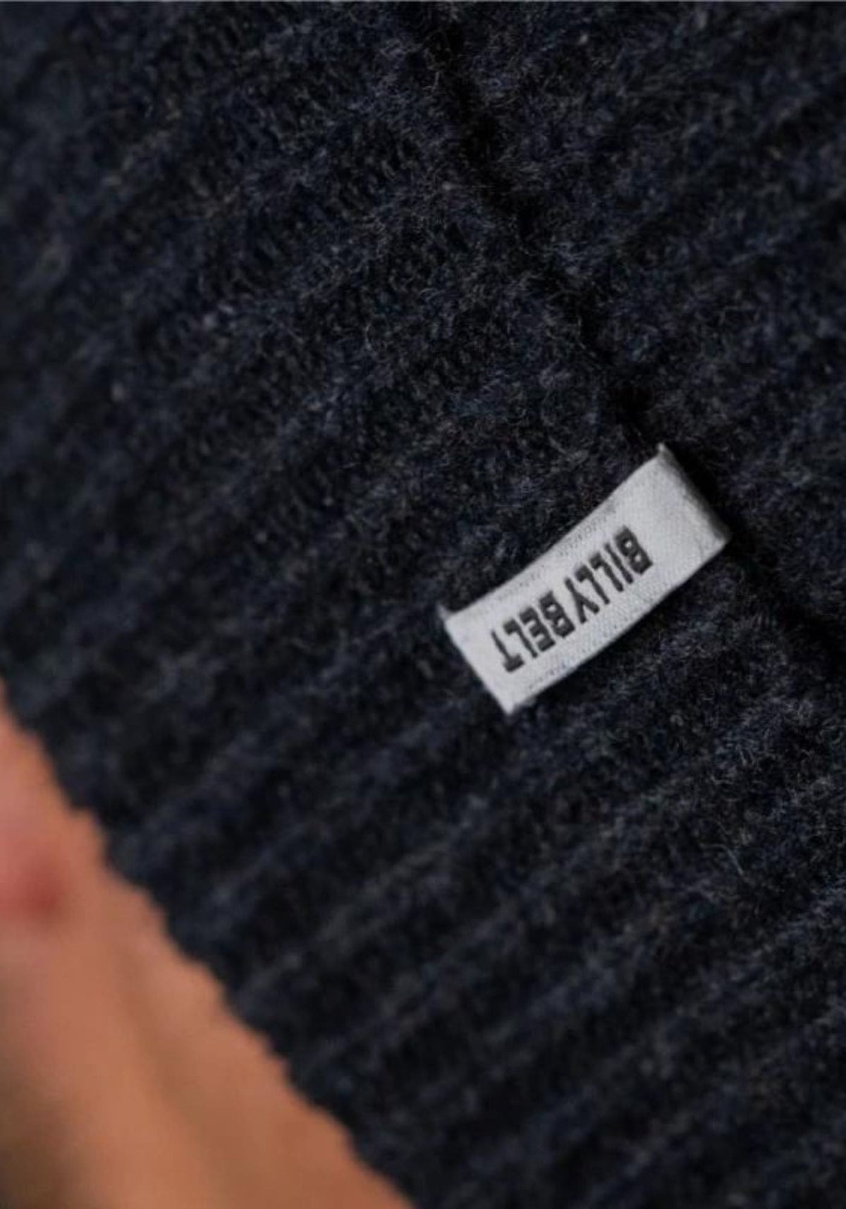 L'homme porte le bonnet en laine bleu marine de chez Billybelt