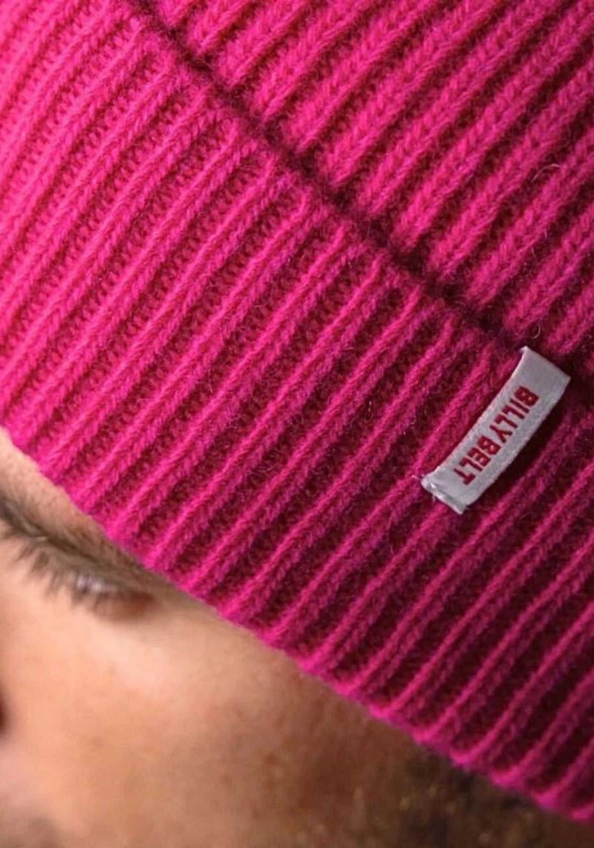 L'homme porte le bonnet en laine rose de chez Billybelt