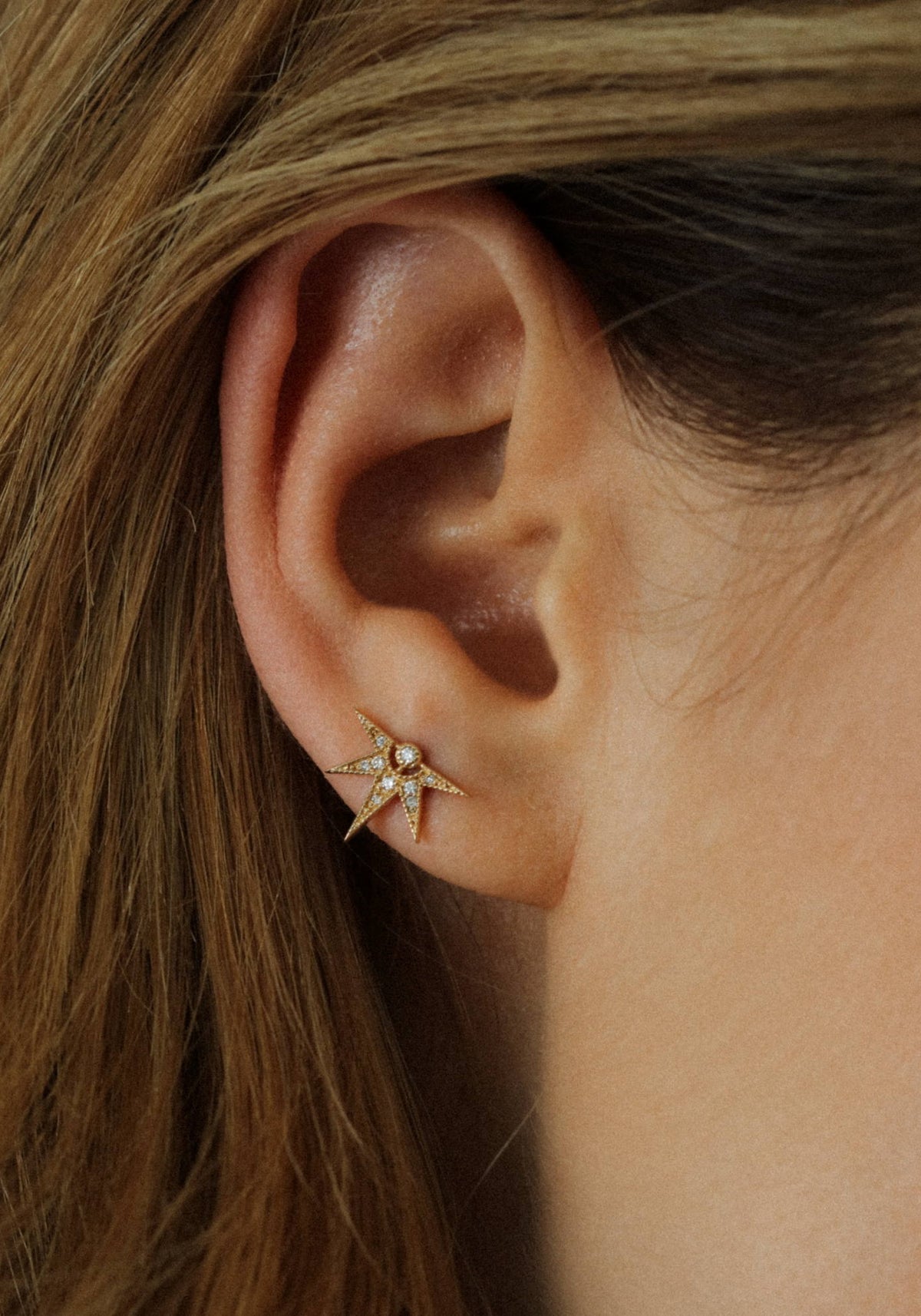 Zoom sur la femme qui porte la boucle d'oreille puce en or jaune Janis de chez Angèle Brousse