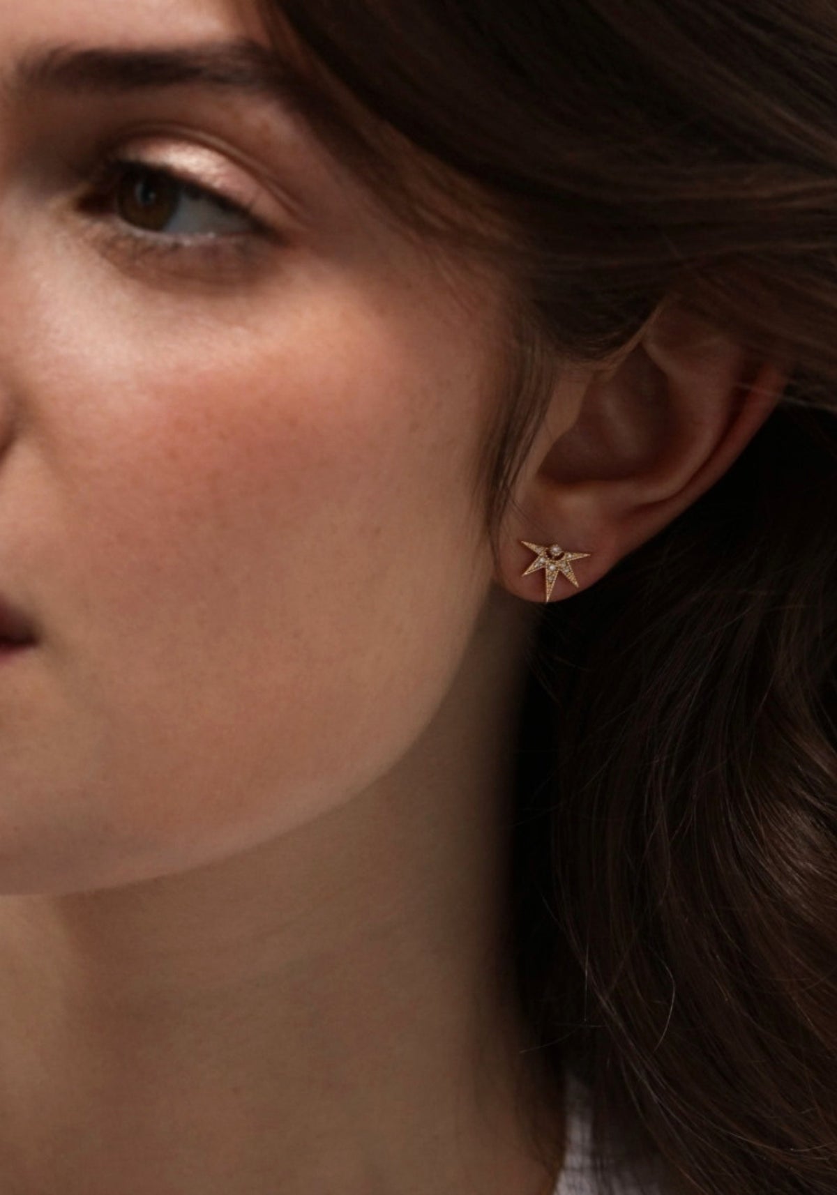 La femme porte la boucle d'oreille puce en or jaune Janis de chez Angèle Brousse