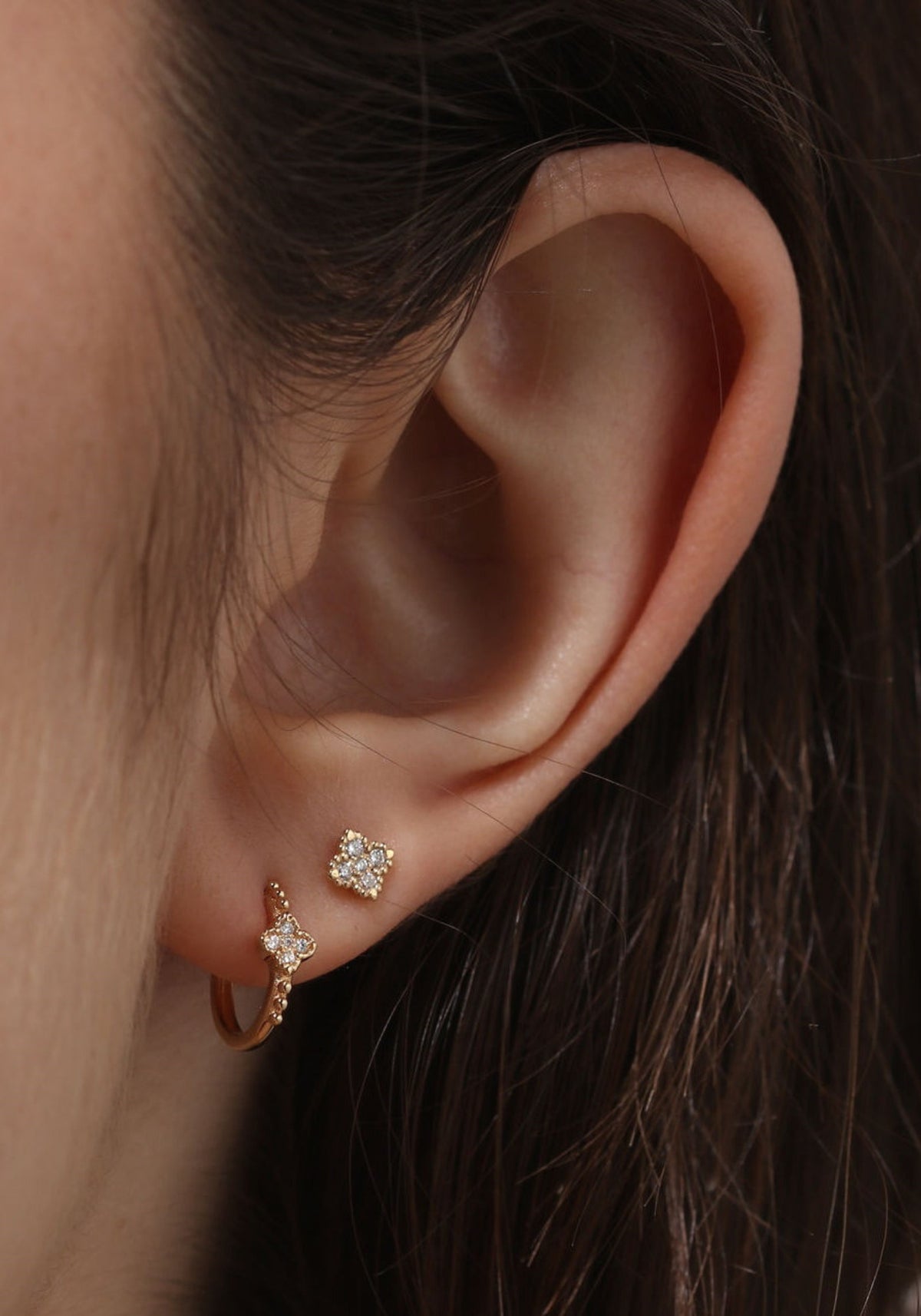 Zoom sur la femme qui porte la boucle d'oreille puce en or jaune Nina One de chez Angèle Brousse