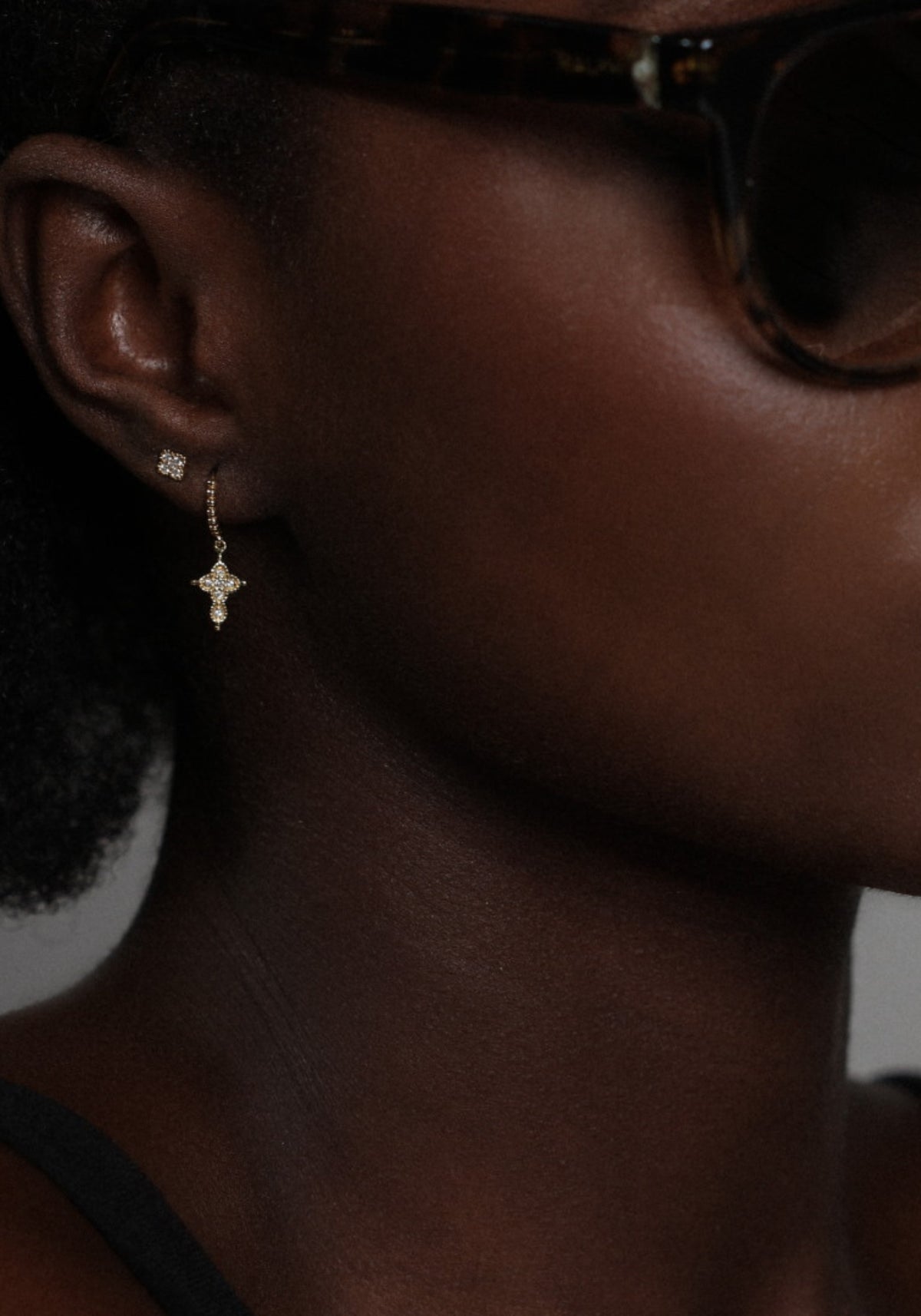 La femme porte la boucle d'oreille puce en or jaune Nina One de chez Angèle Brousse
