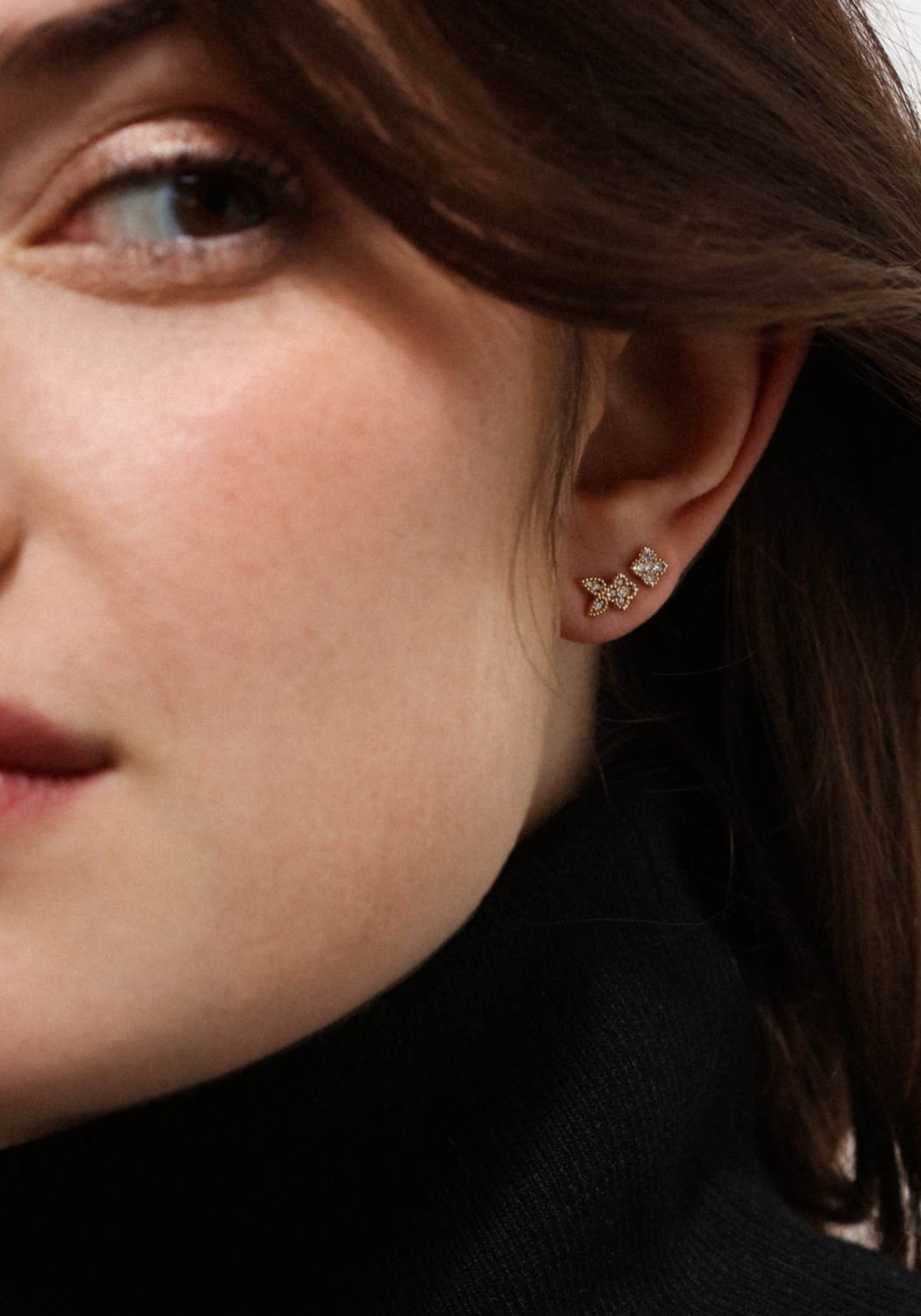 La femme porte la boucle d'oreille puce en or jaune Nina One de chez Angèle Brousse