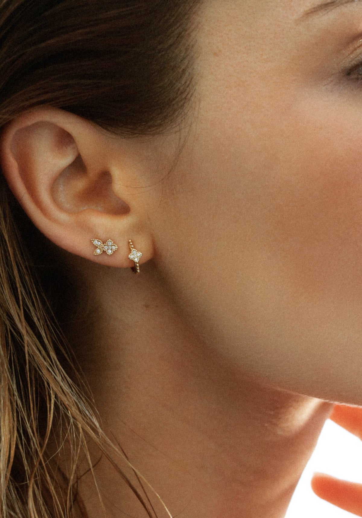 La femme porte la boucle d'oreille puce en or jaune Nina Rabbit de chez Angèle Brousse