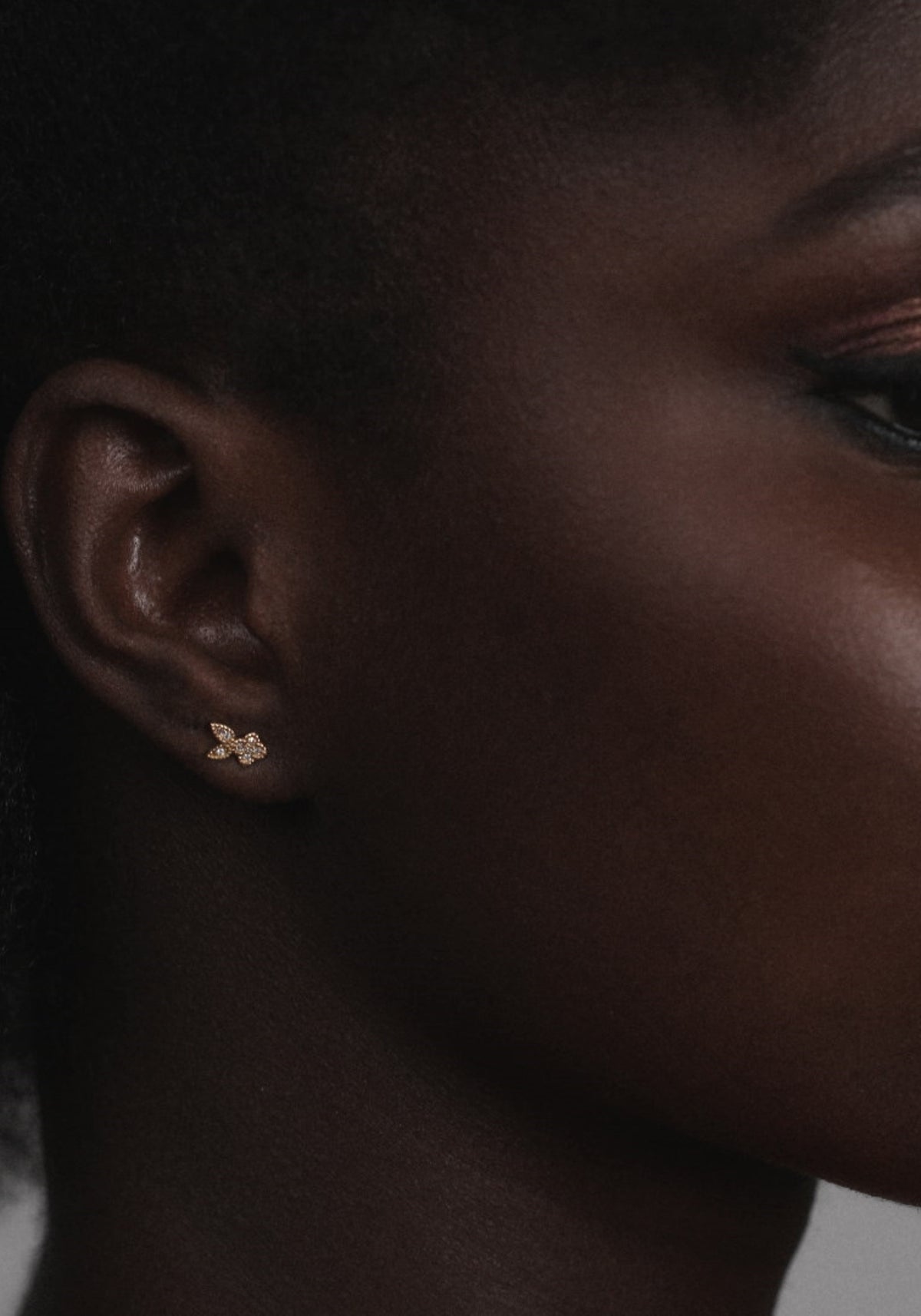 La femme porte la boucle d'oreille puce en or jaune Nina Rabbit de chez Angèle Brousse
