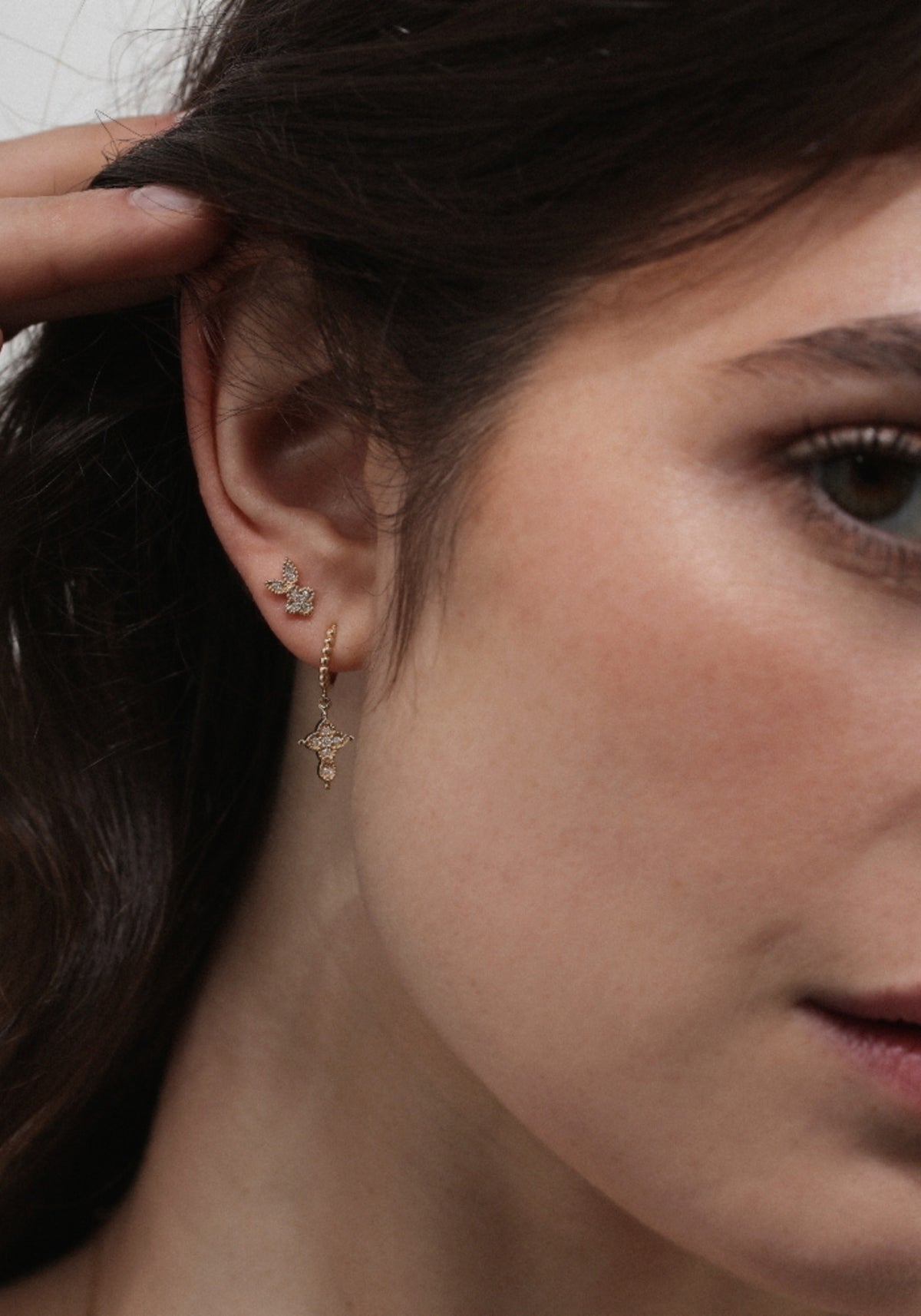 La femme porte la boucle d'oreille puce en or jaune Nina Rabbit de chez Angèle Brousse
