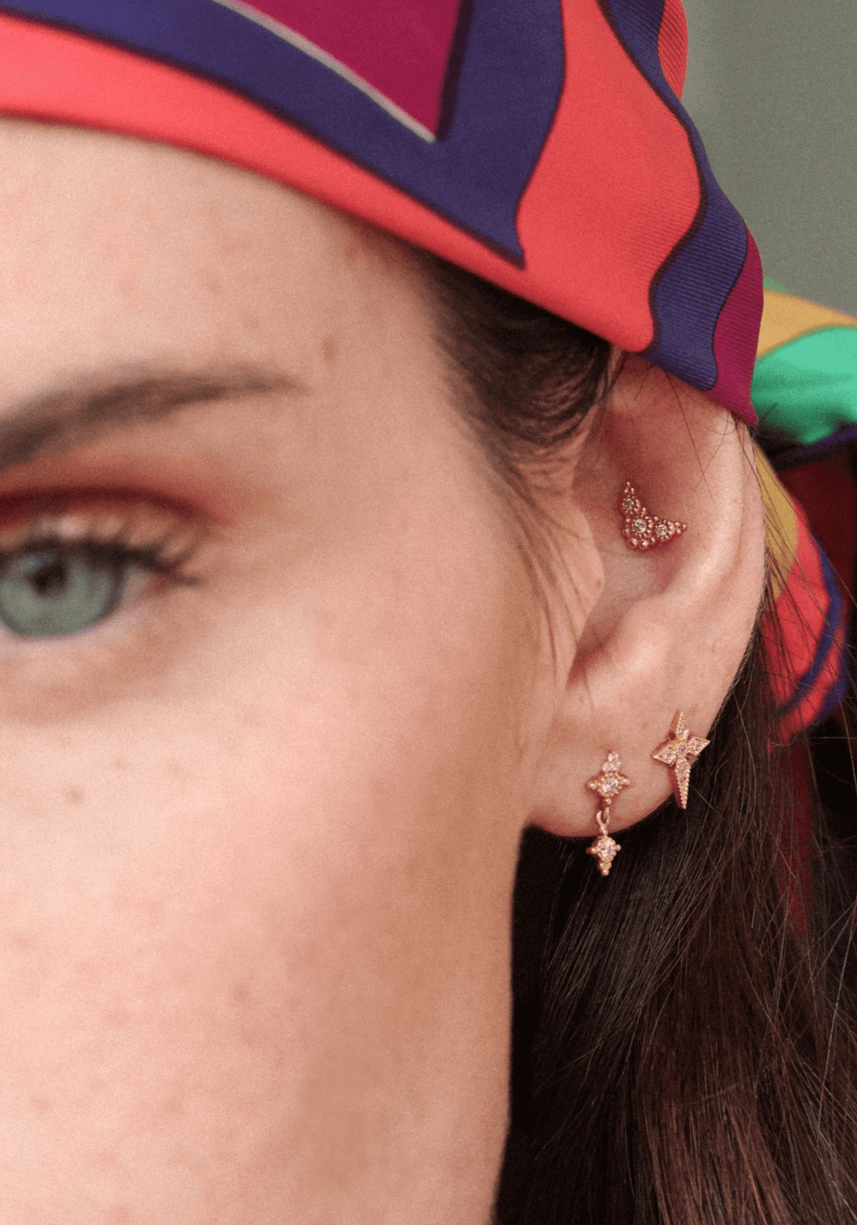 La femme porte la boucle d'oreille Puce Susie en or jaune de chez Angèle Brousse en tant que piercing