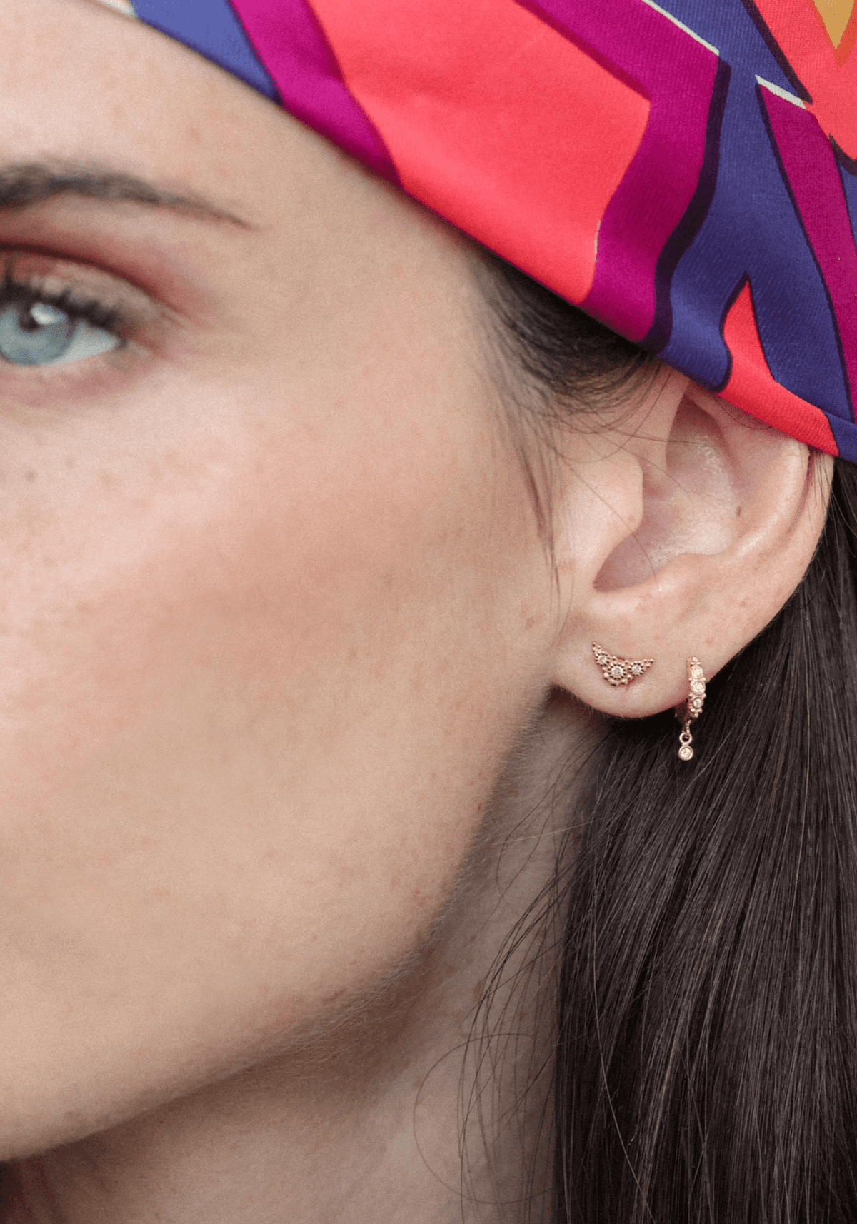 La femme porte la boucle d'oreille Puce Susie en or jaune de chez Angèle Brousse