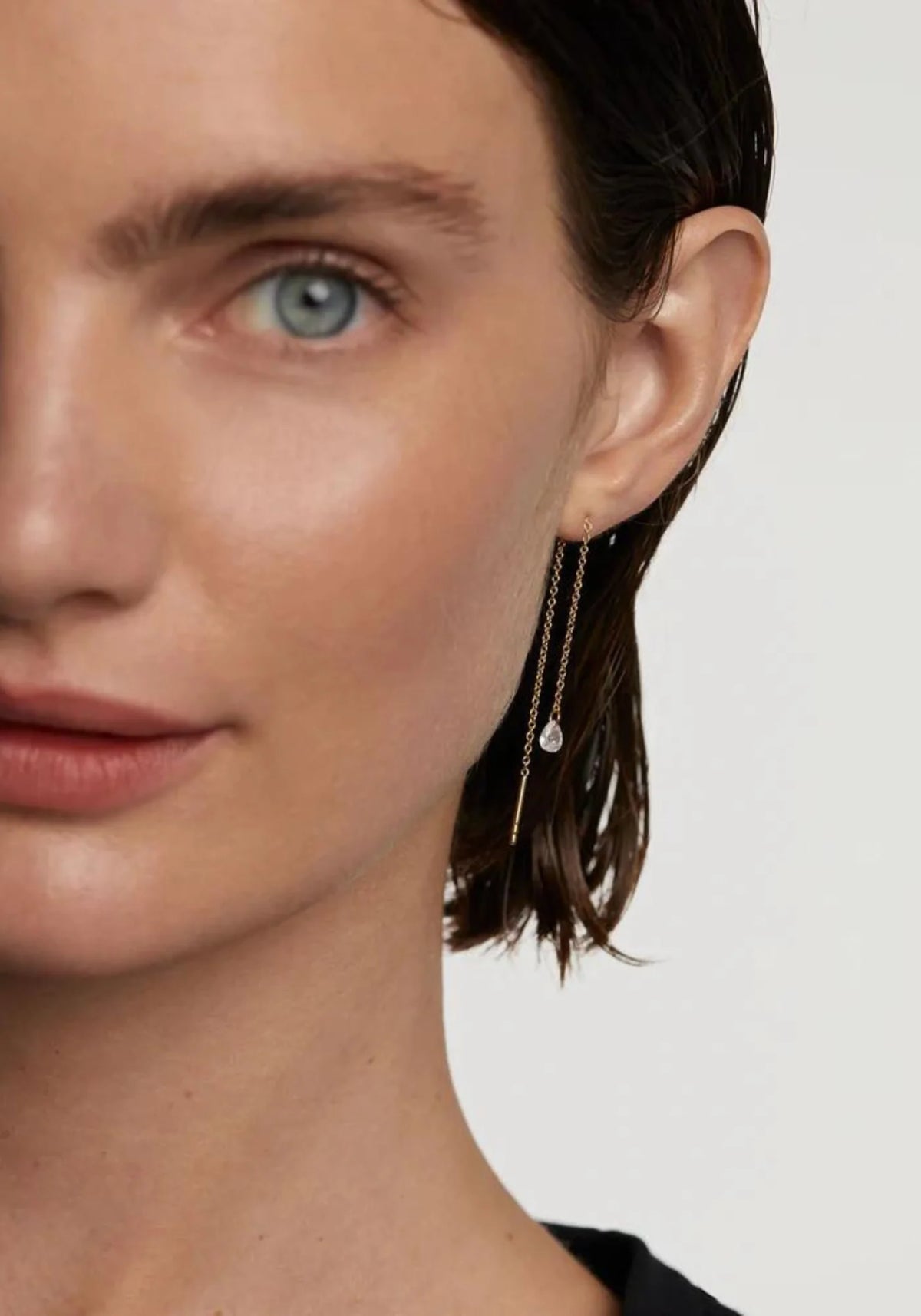La femme porte les boucles d'oreilles Waterfall en or jaune 18 carats de chez PD Paola