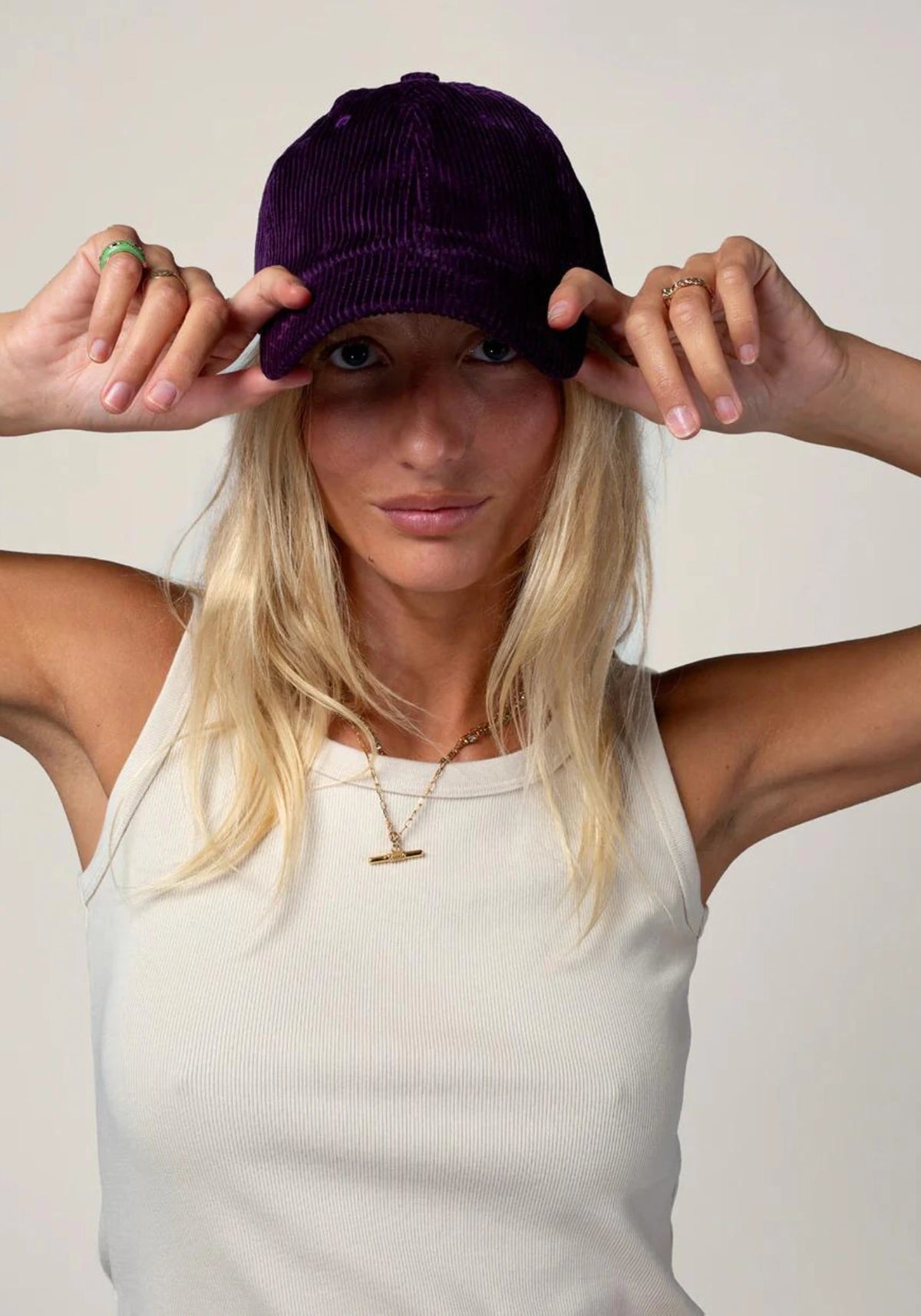 la femme porte la casquette en velours mixte prune de chez Cotelé Paris 