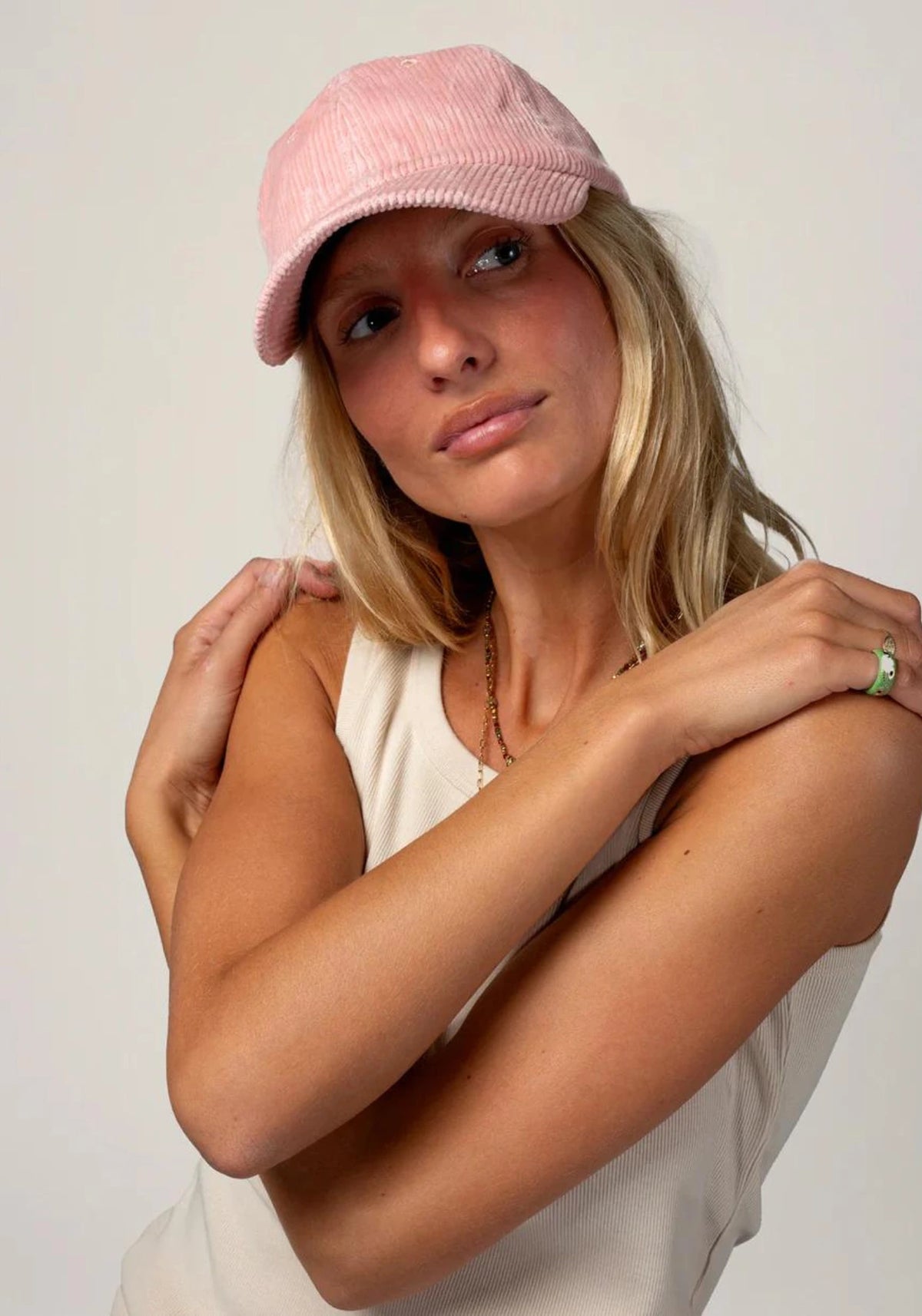 la femme porte la casquette en velours mixte rose de chez Cotelé Paris 