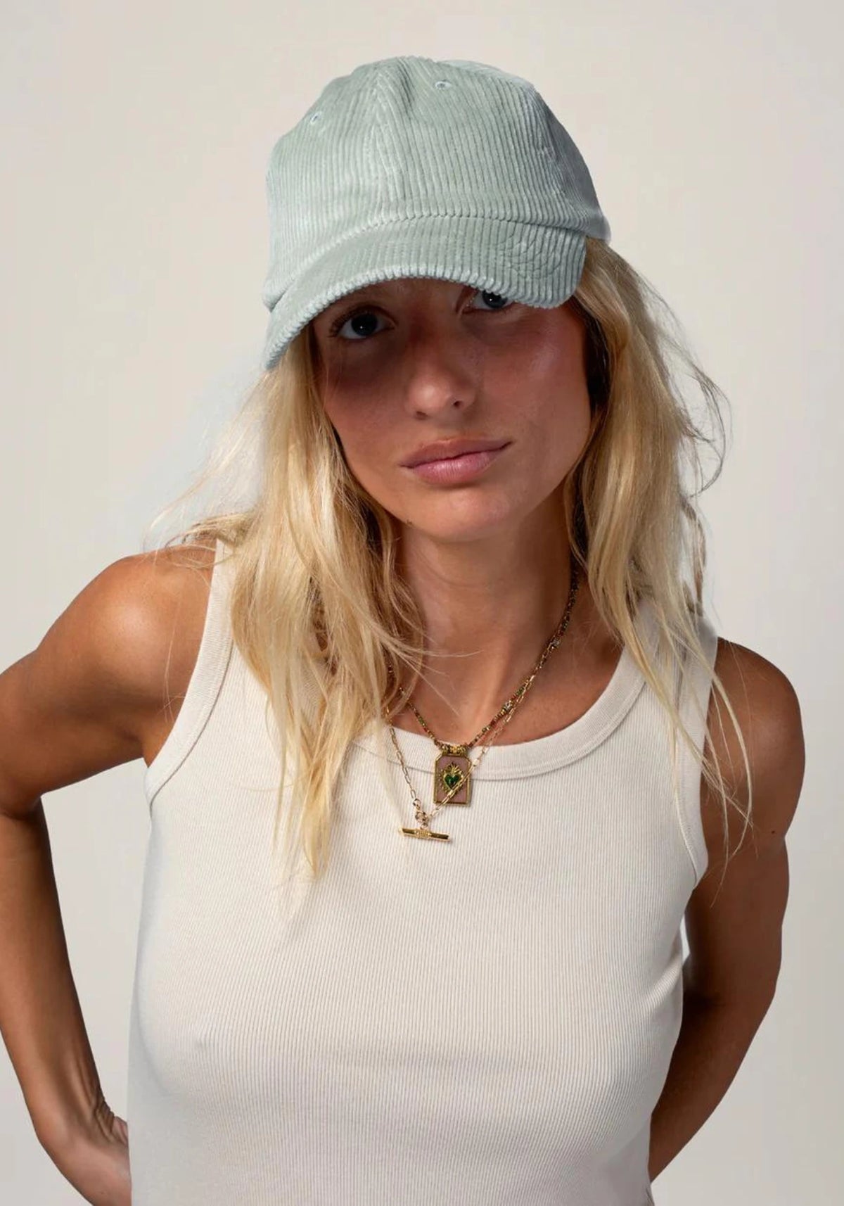la femme porte la casquette en velours mixte sauge de chez Cotelé Paris 