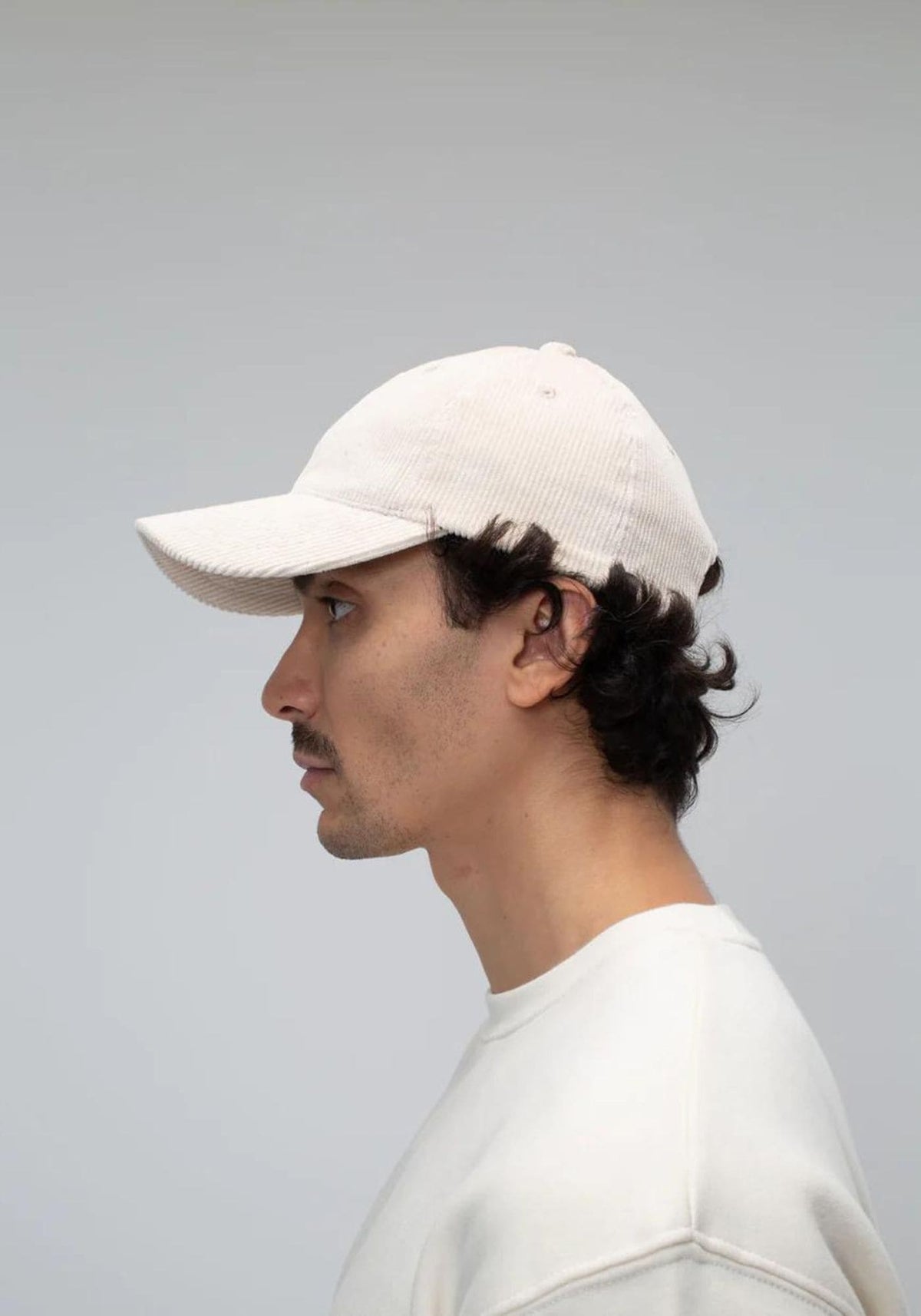 L'homme porte la casquette en velours sable de chez Côtelé Paris, vue de côté