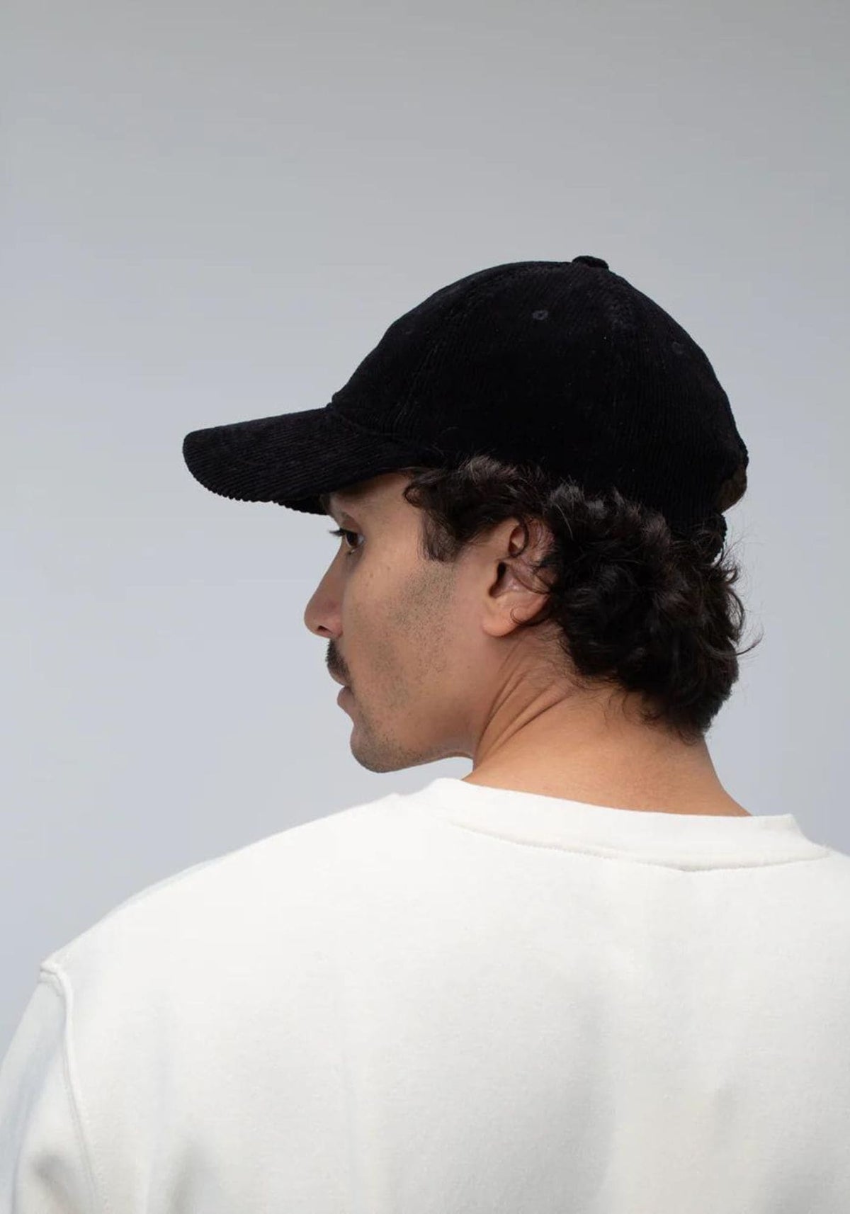 L'homme porte la casquette en velours noir de chez Côtelé Paris