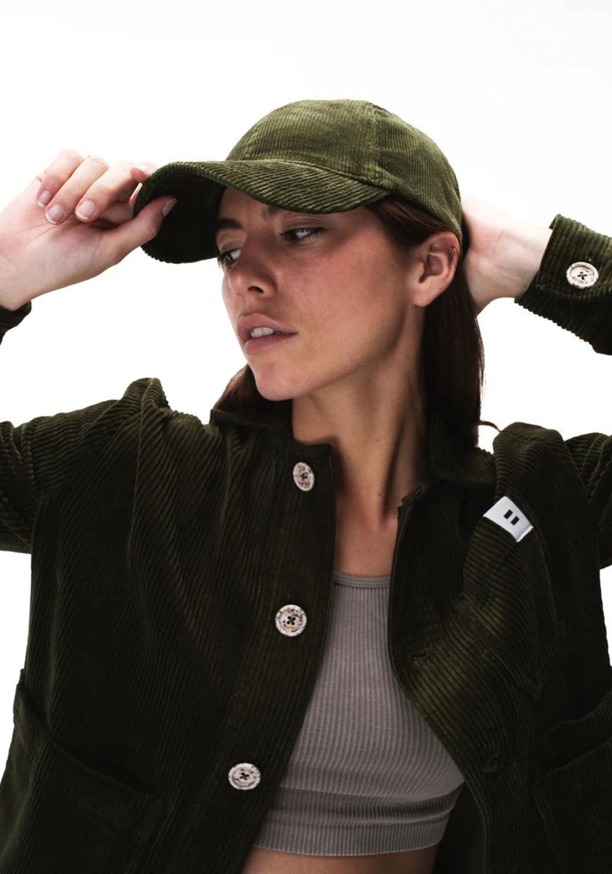 La femme porte la casquette en velours vert olive de chez Côtelé Paris
