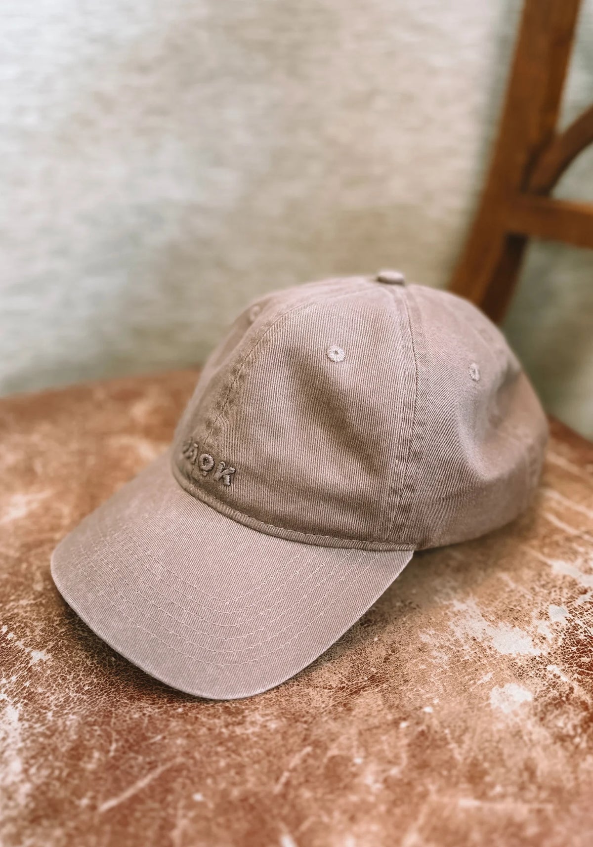 La casquette Vic noix de chez Jaqk posée sur une chaise en bois