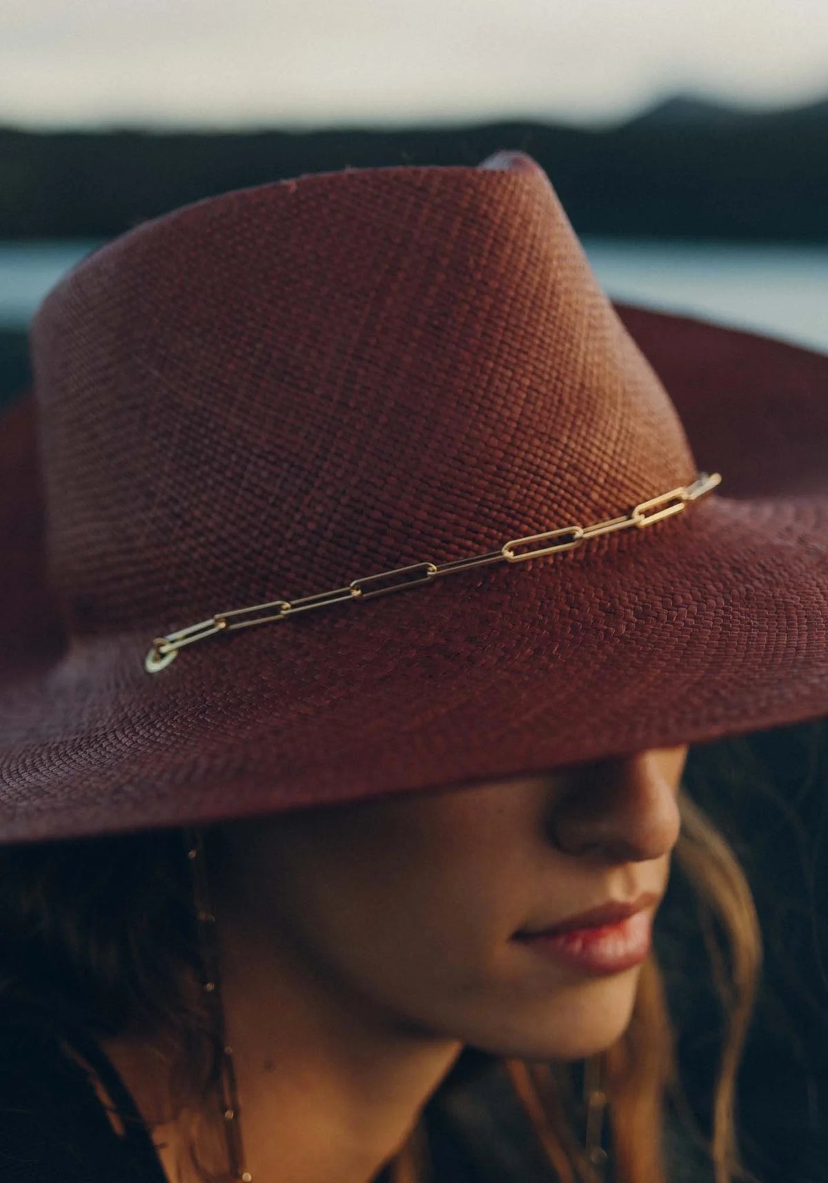 Zoom sur la femme qui porte le chapeau de paille avec chaîne Livy Junior auburn de chez Van Palma