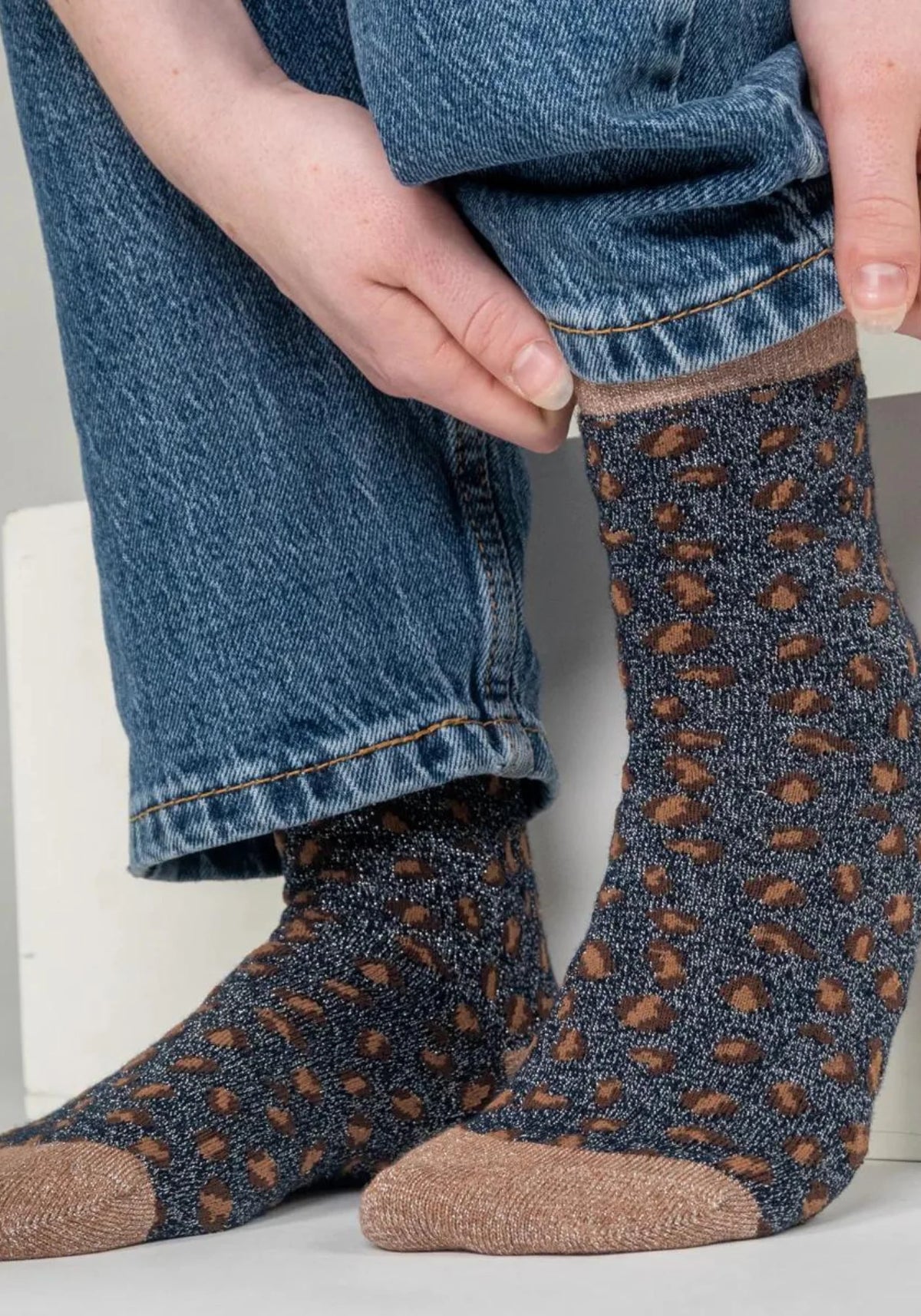 La femme porte les chaussettes à motif léopard marine et marron de chez Billybelt