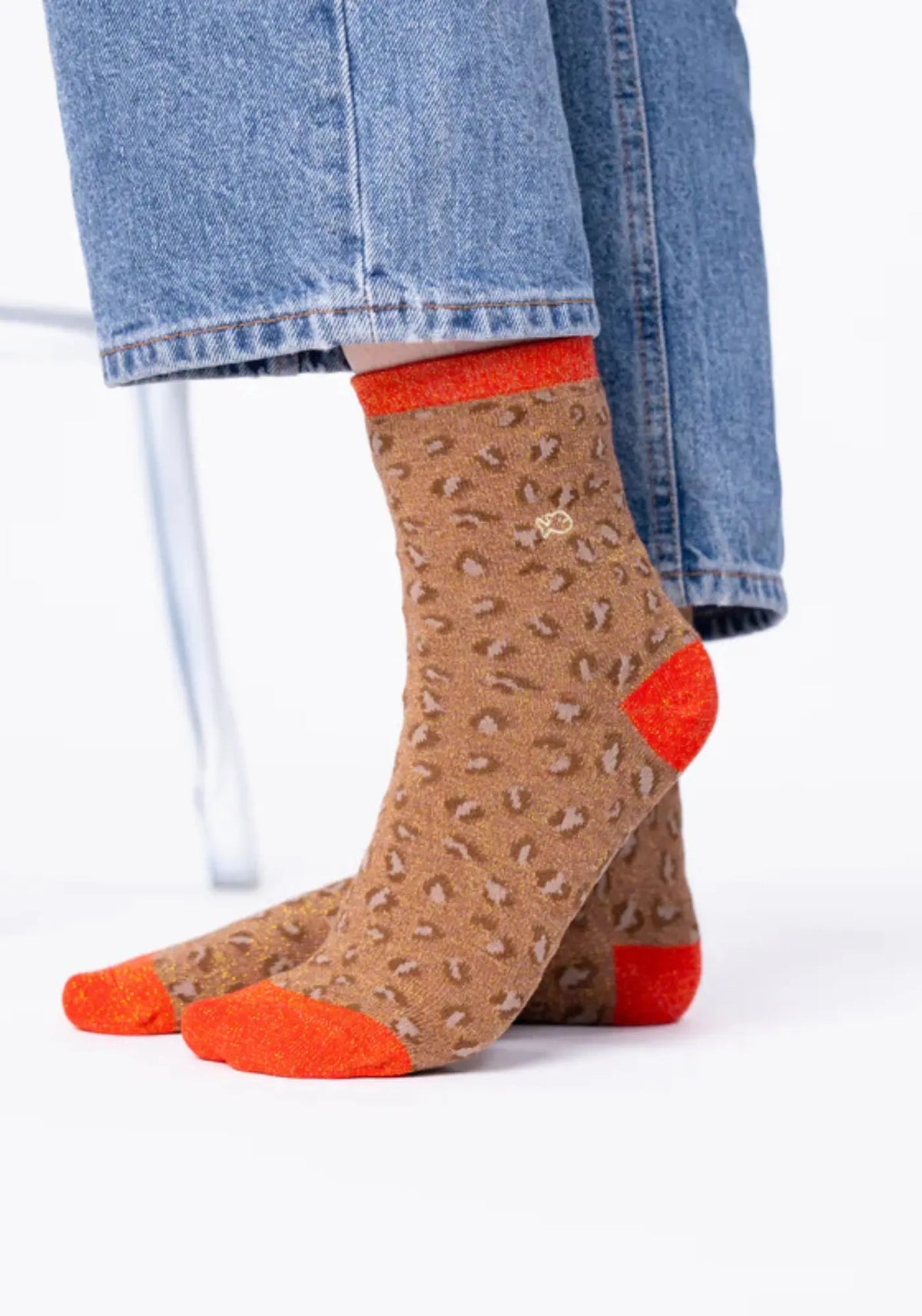 La femme porte les chaussettes à motif leopard marron et orange de chez Billybelt