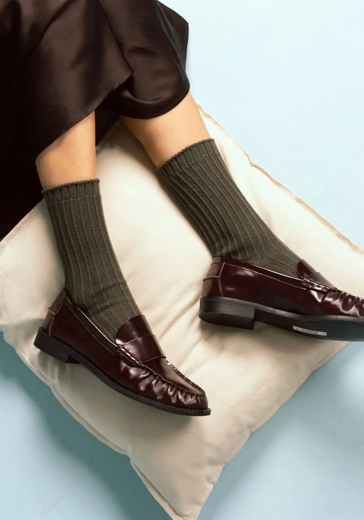 Le mannequin porte les chaussettes en coton biologique khaki solid knitted de chez Klue