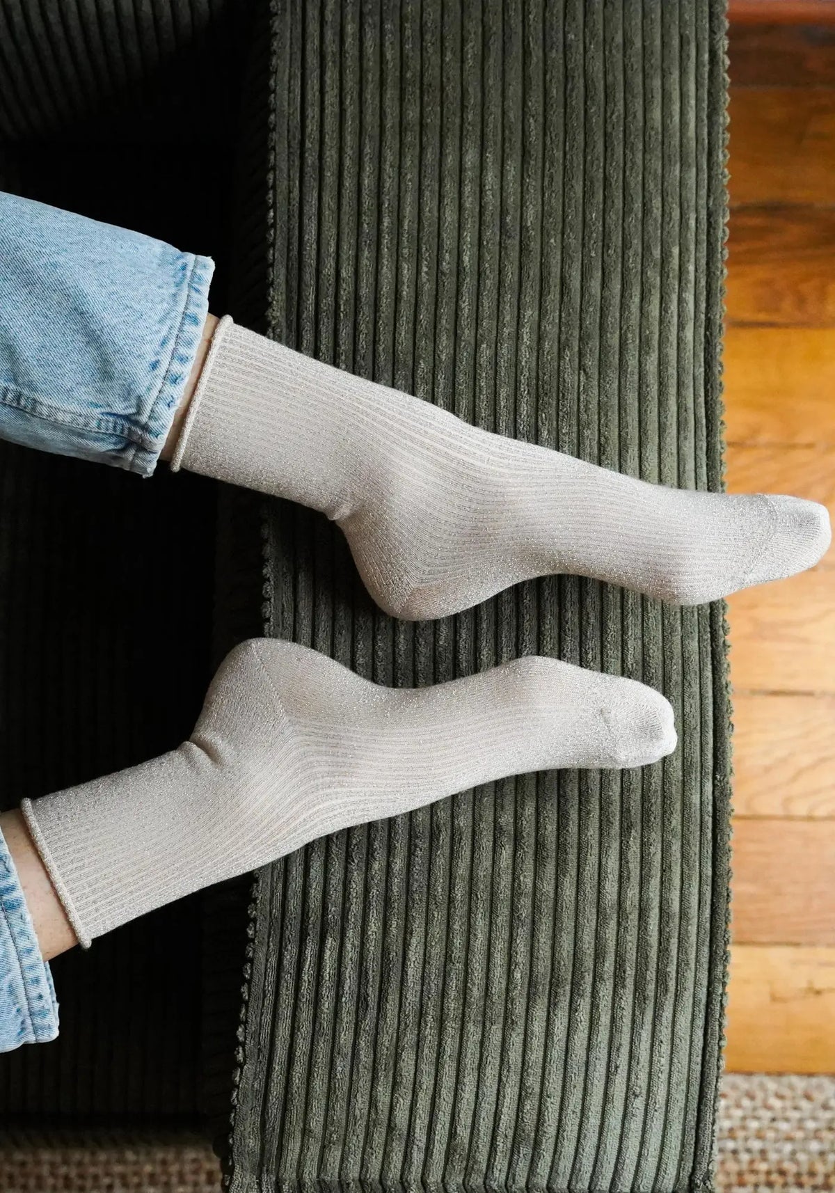 Le mannequin porte les chaussettes lurex beige de chez Klue