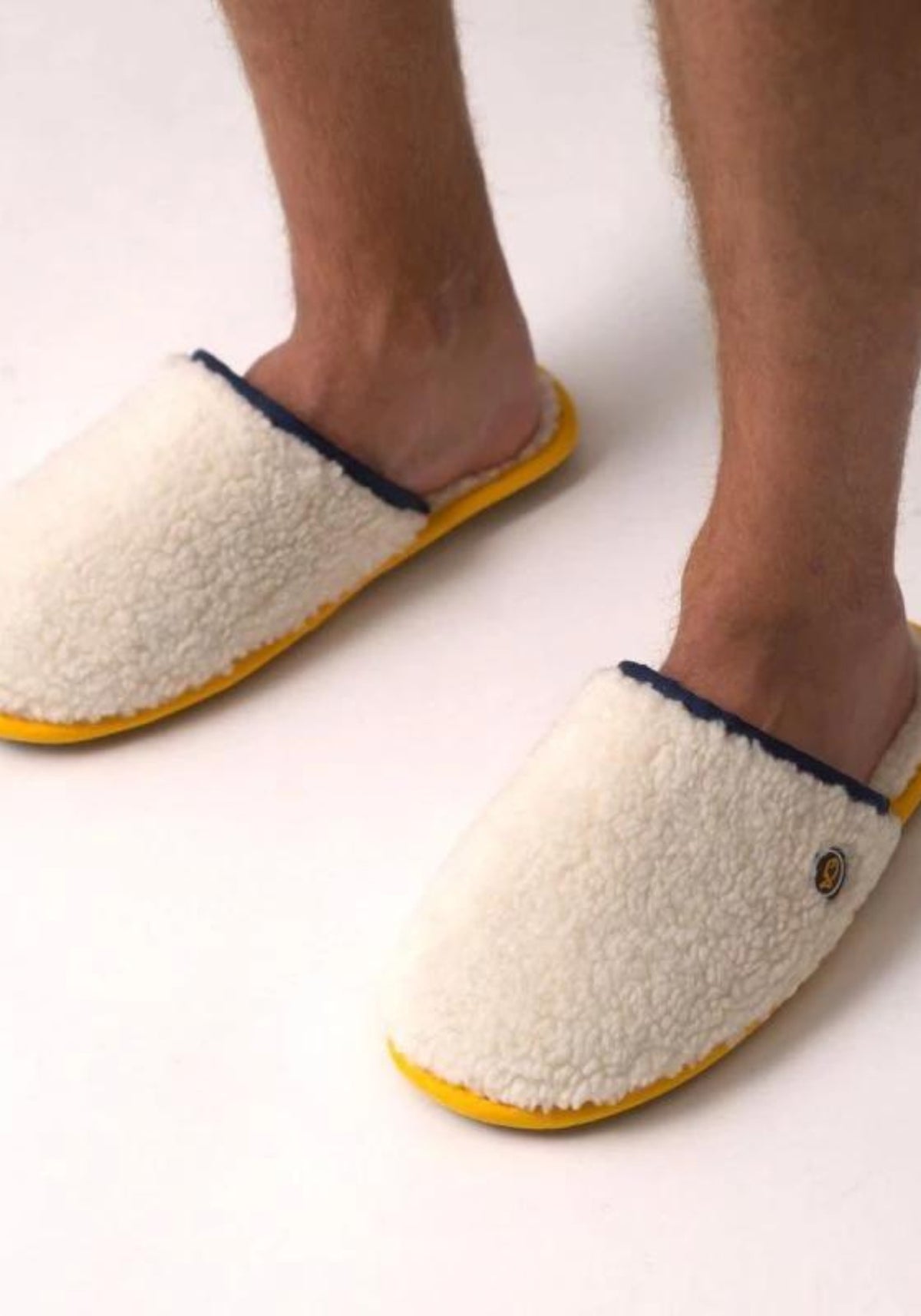 L'homme porte les chaussons Sherpa beige de chez Billybelt