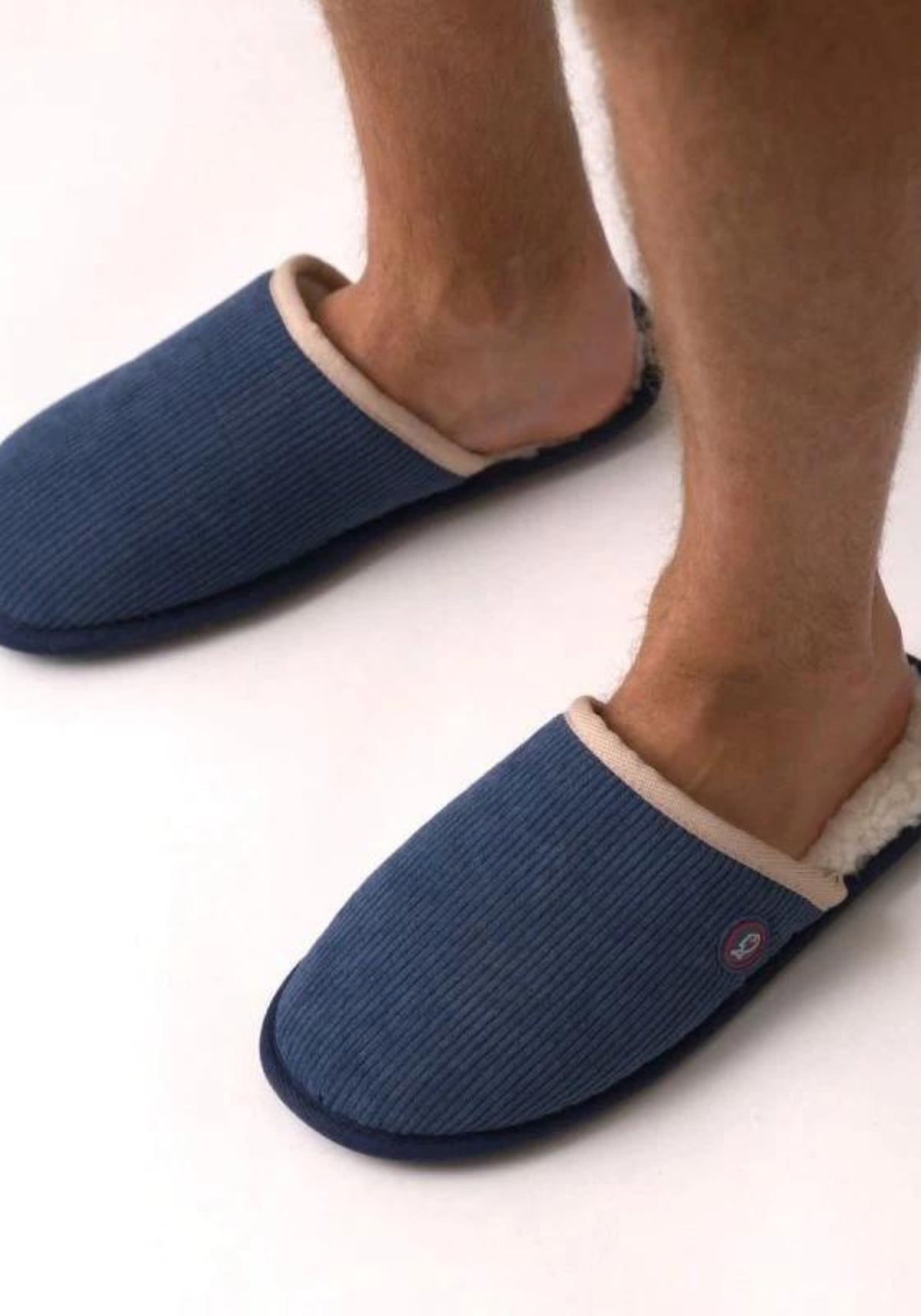 L'homme porte les chaussons en velours marine de chez Billybelt