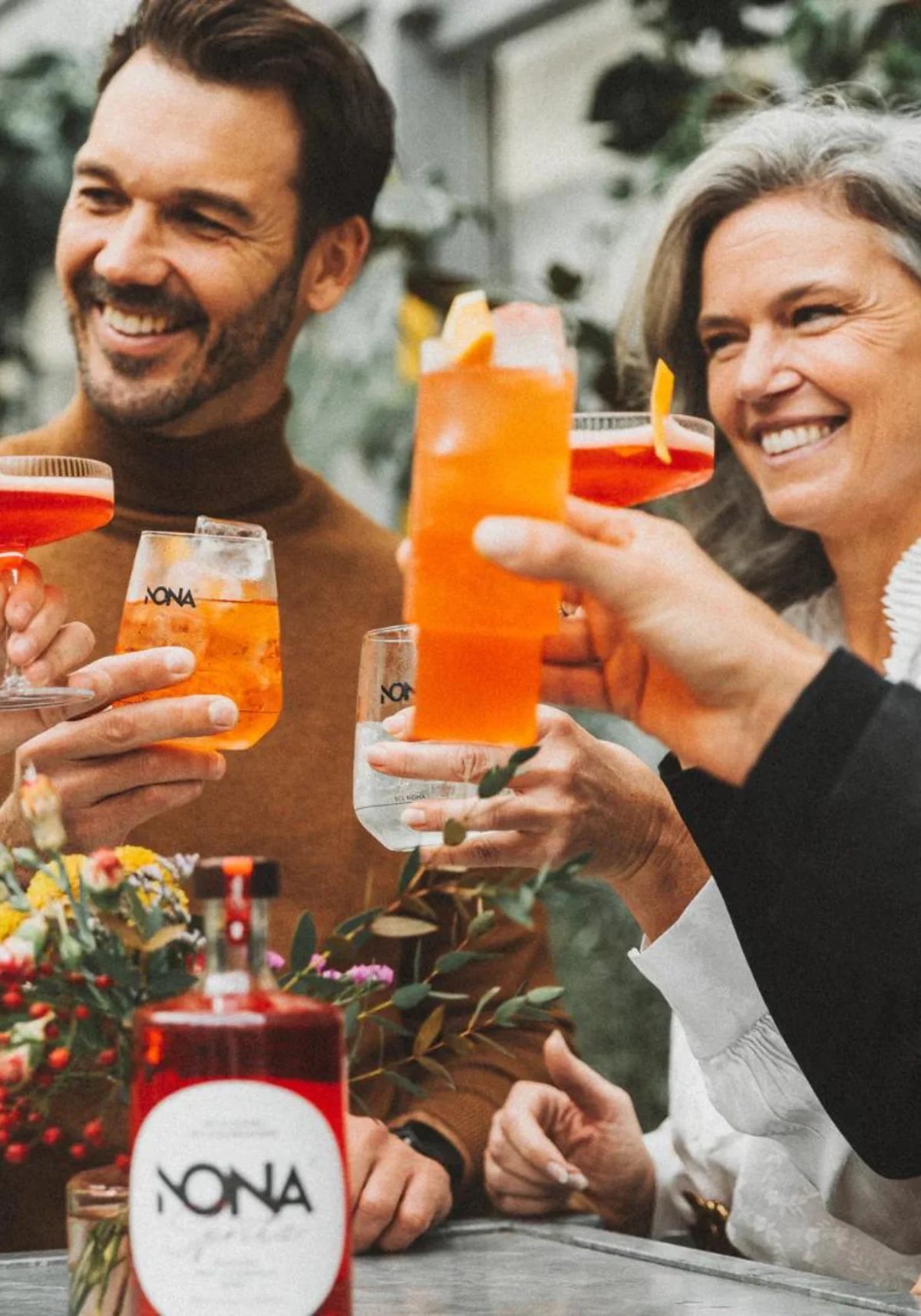 Des amis trinquent avec le cocktail sans alcool Nona Spritz de chez Nona Drinks