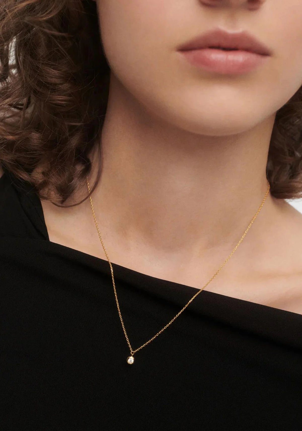 La femme porte le collier solitaire Sand en or jaune 18 carats de chez PD Paola