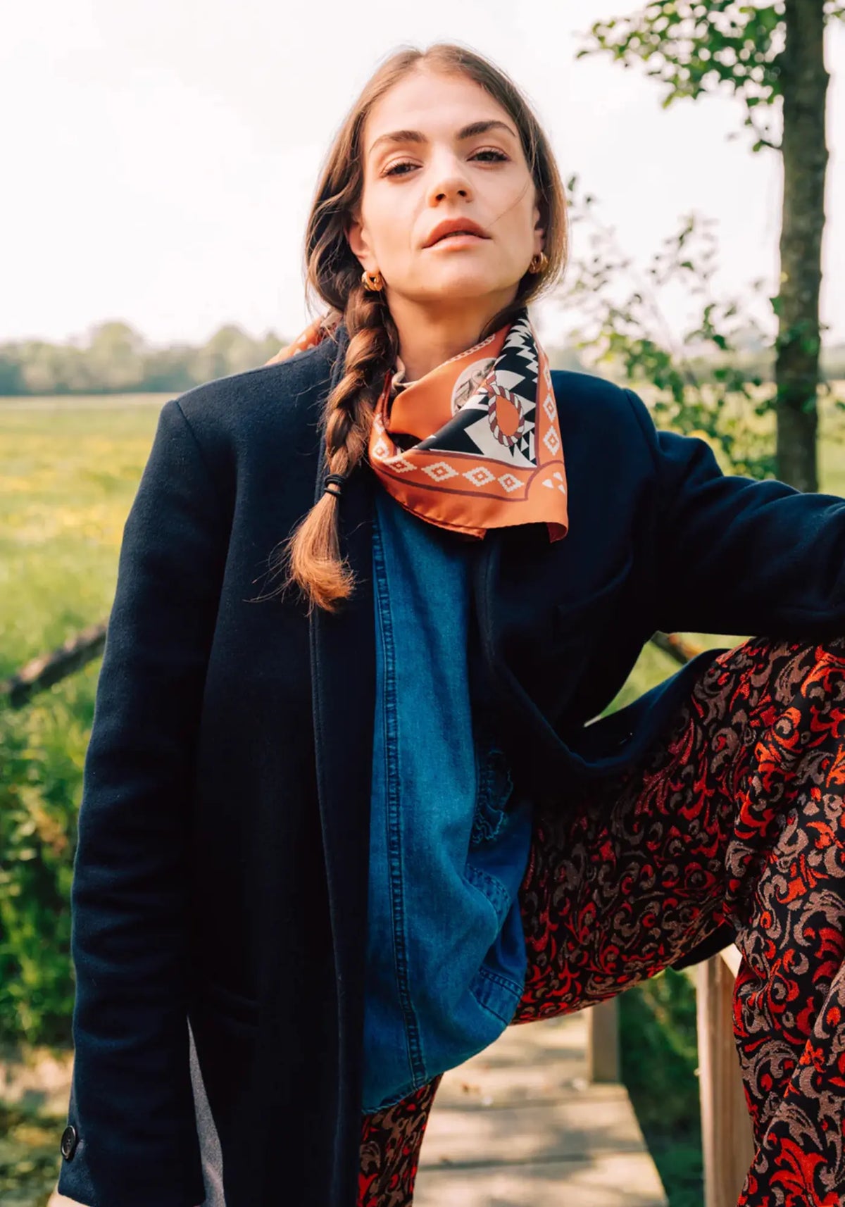 La femme porte le foulard dusty west silk 70 brick de chez Antan Créations
