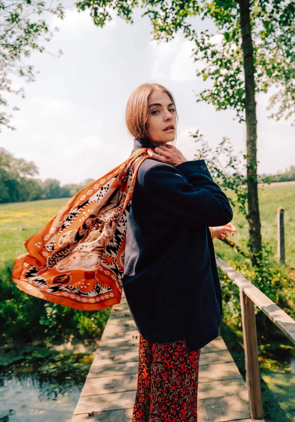 La femme porte le foulard dusty west silk 70 brick de chez Antan Créations