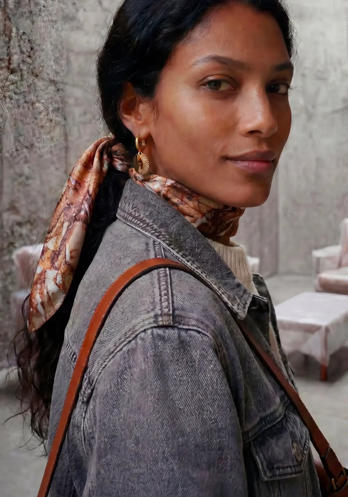 La femme porte le foulard granit marbre rose de chez Antan Créations