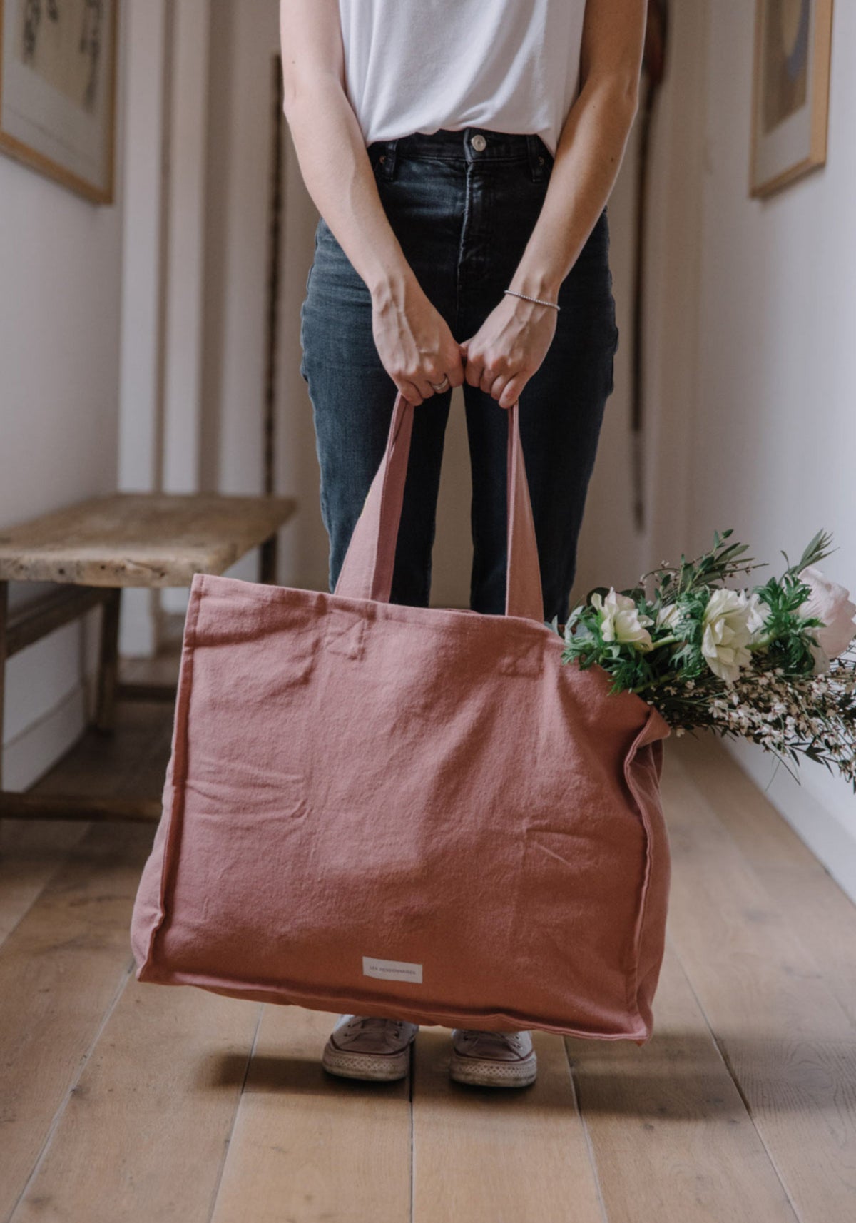 La femme tient le grand sac cabas bois de rose de chez Les Pensionnaires