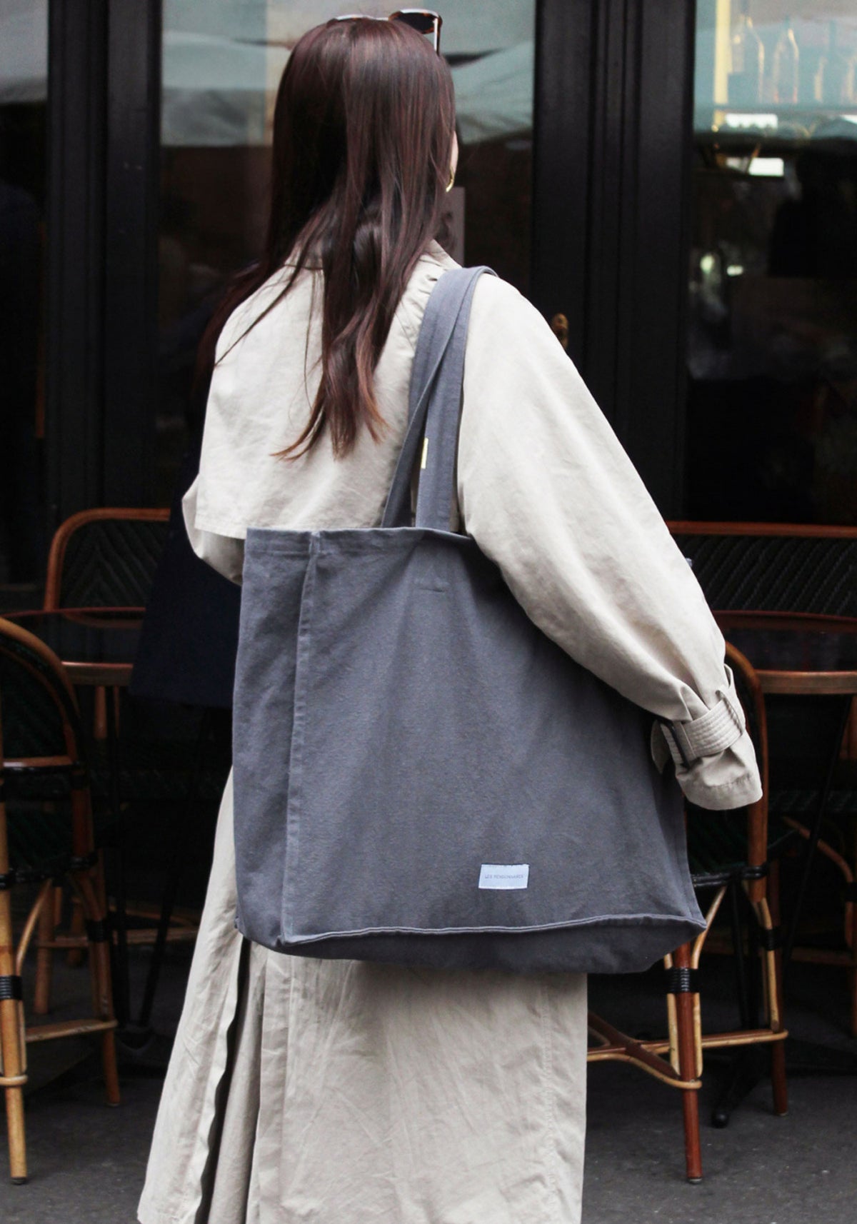 La femme porte le grand sac cabas gris ardoise de chez Les Pensionnaires