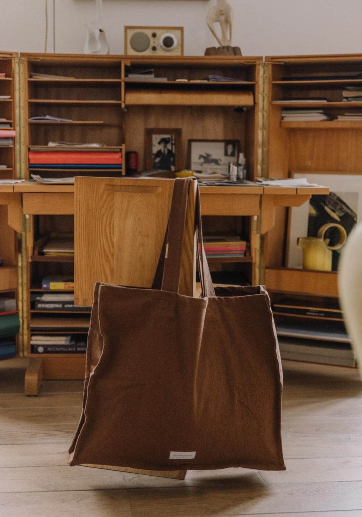 Le grand sac cabas noisette de chez Les Pensionnaires suspendu à une chaise