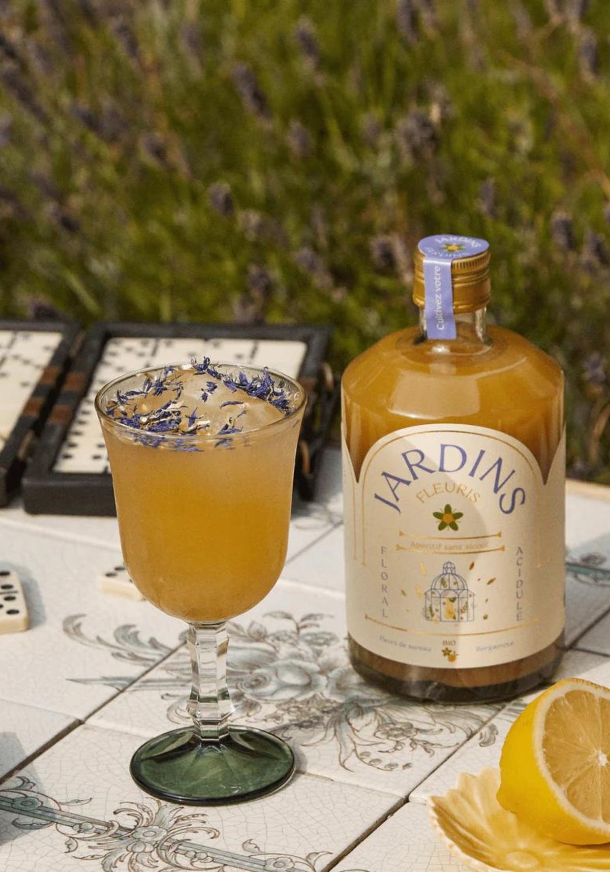 Bouteille Jardins fleurs de sureau et bergamote avec verre rempli.