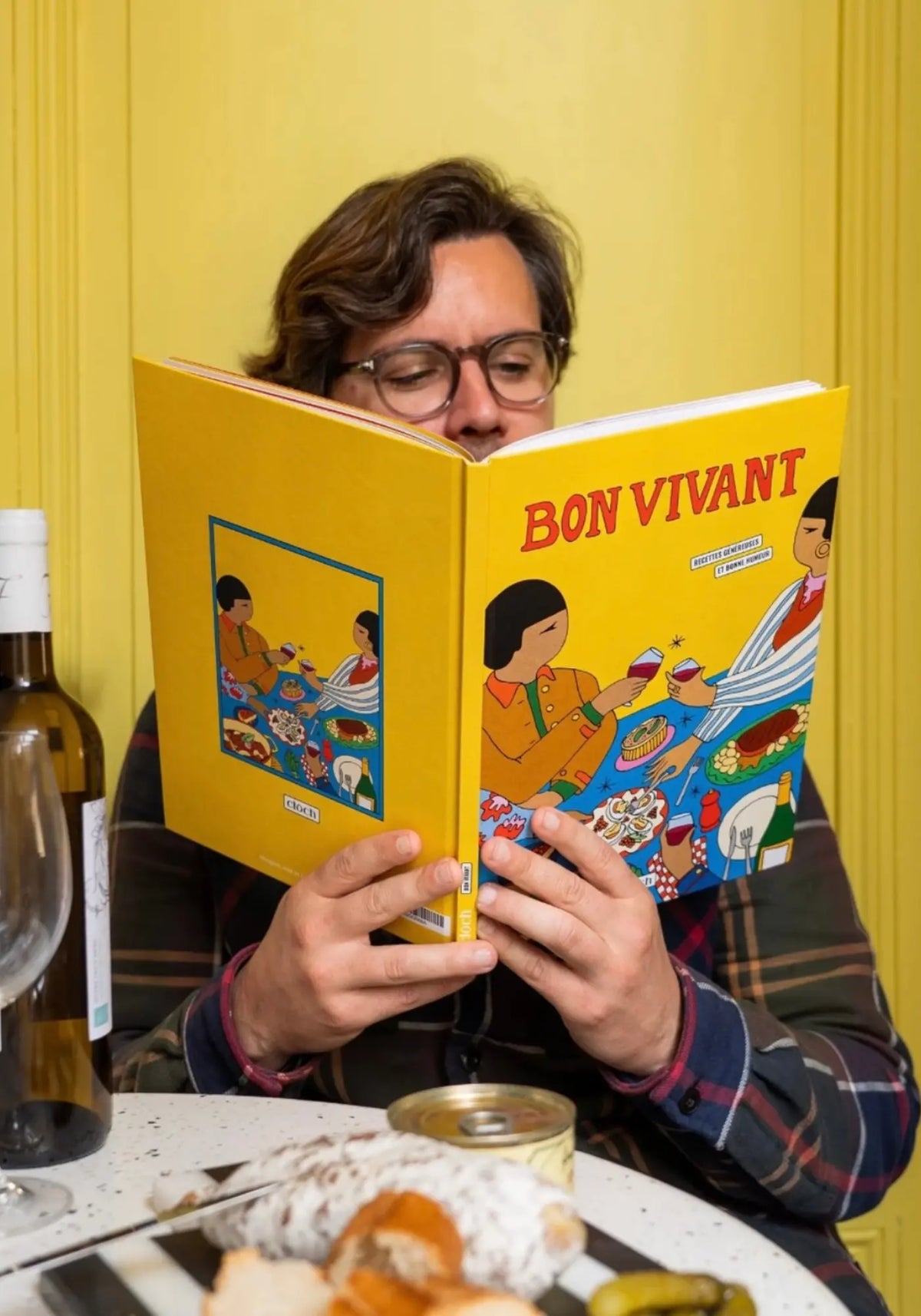 L'homme tient le livre de recettes bon vivant de chez Cloch